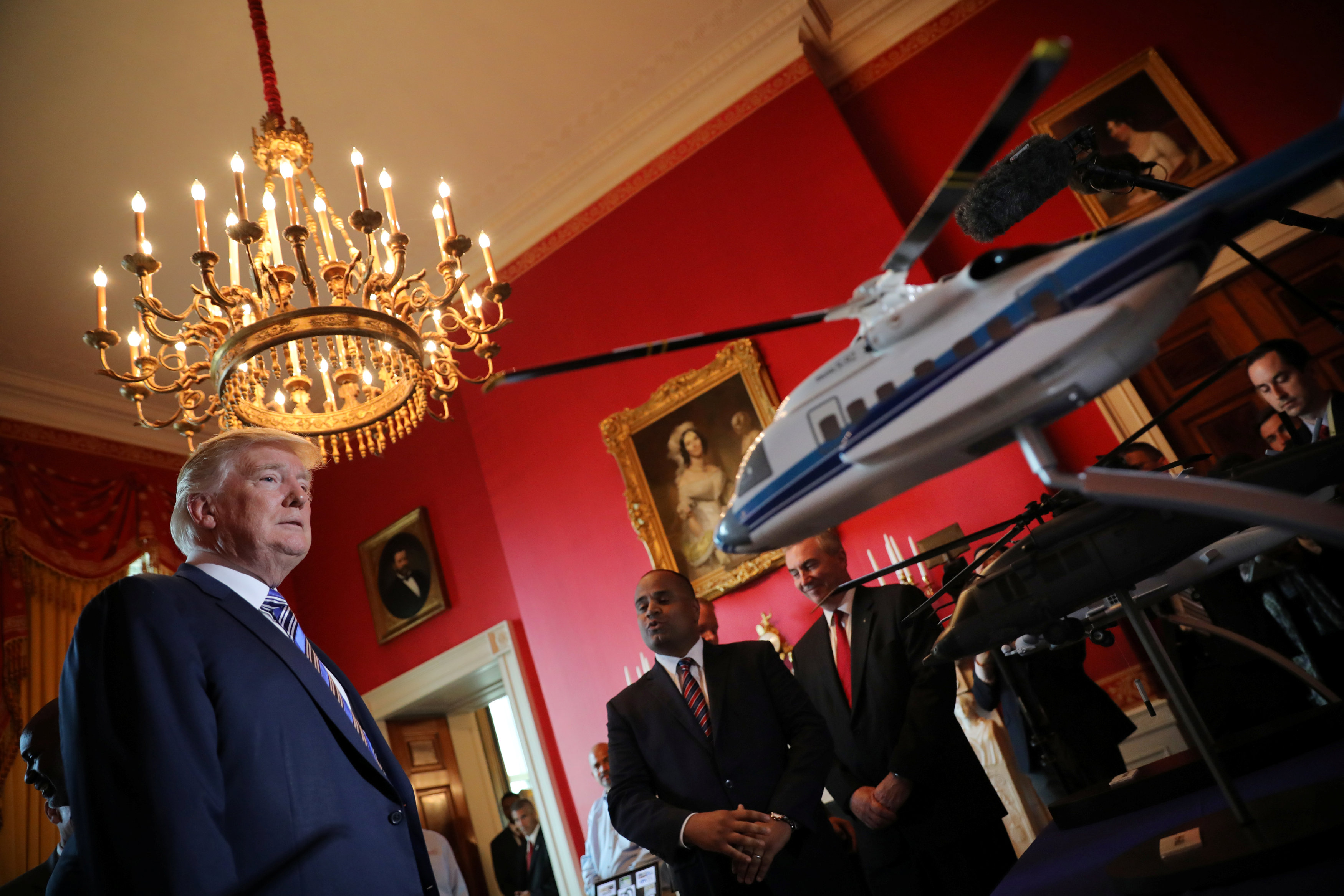 ترامب يقف امام نموذج لطيارة أمريكية