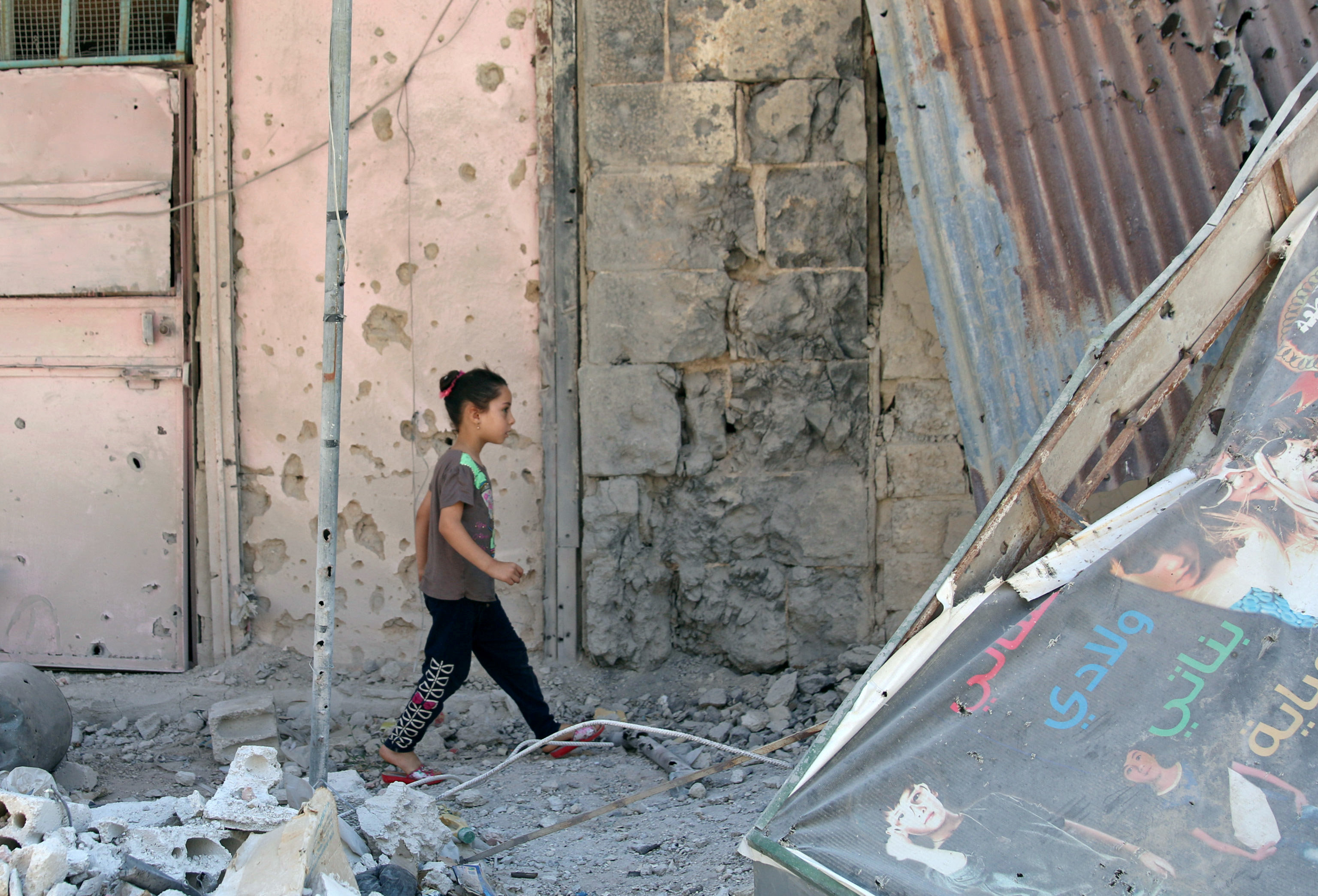 طفلة سورية تلهو وسط أنقاض الحرب