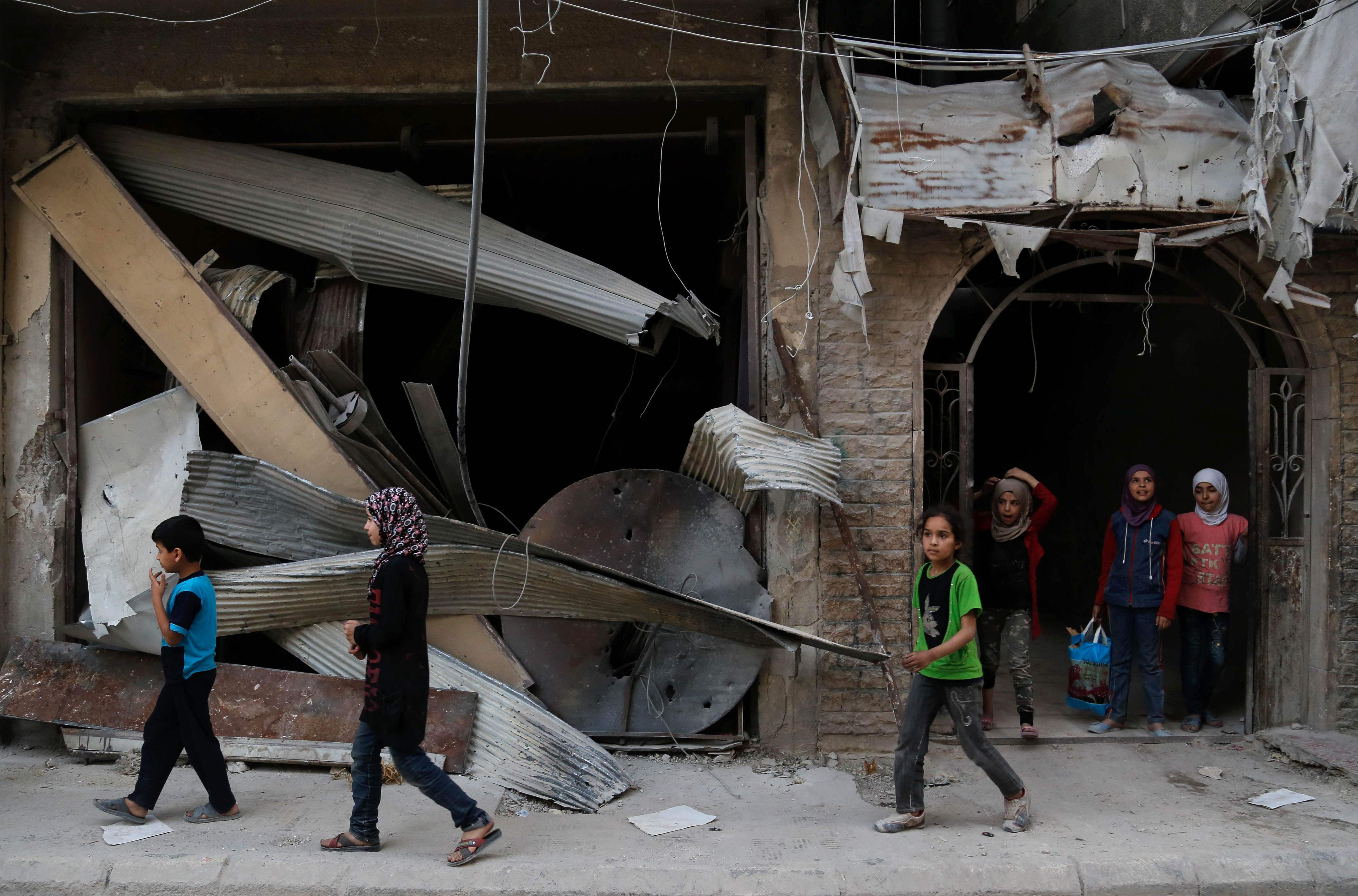 الأطفال السوريون يلعبون وسط المنازل المهدمة
