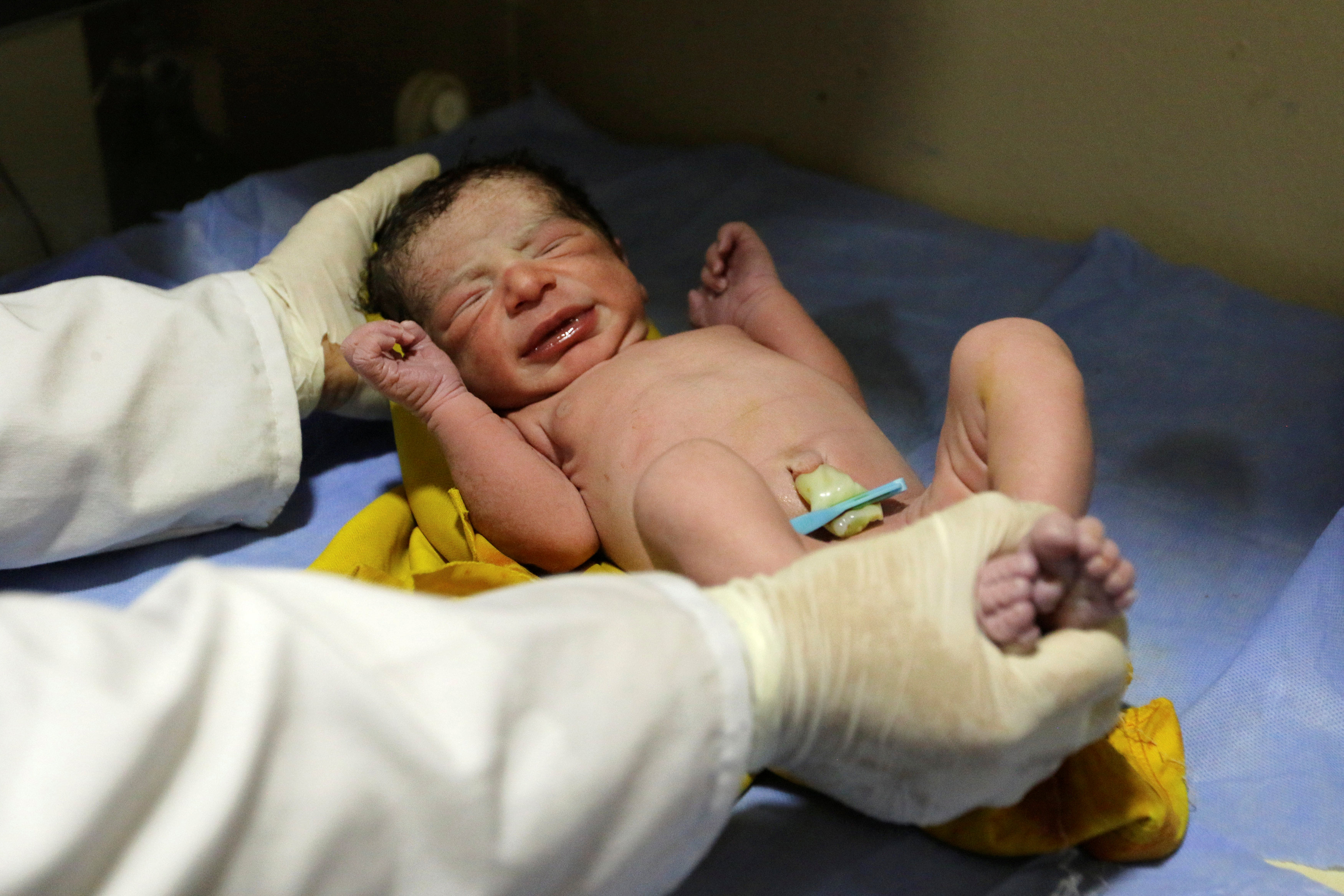 طفل يحمل رضيع حديث الولادة
