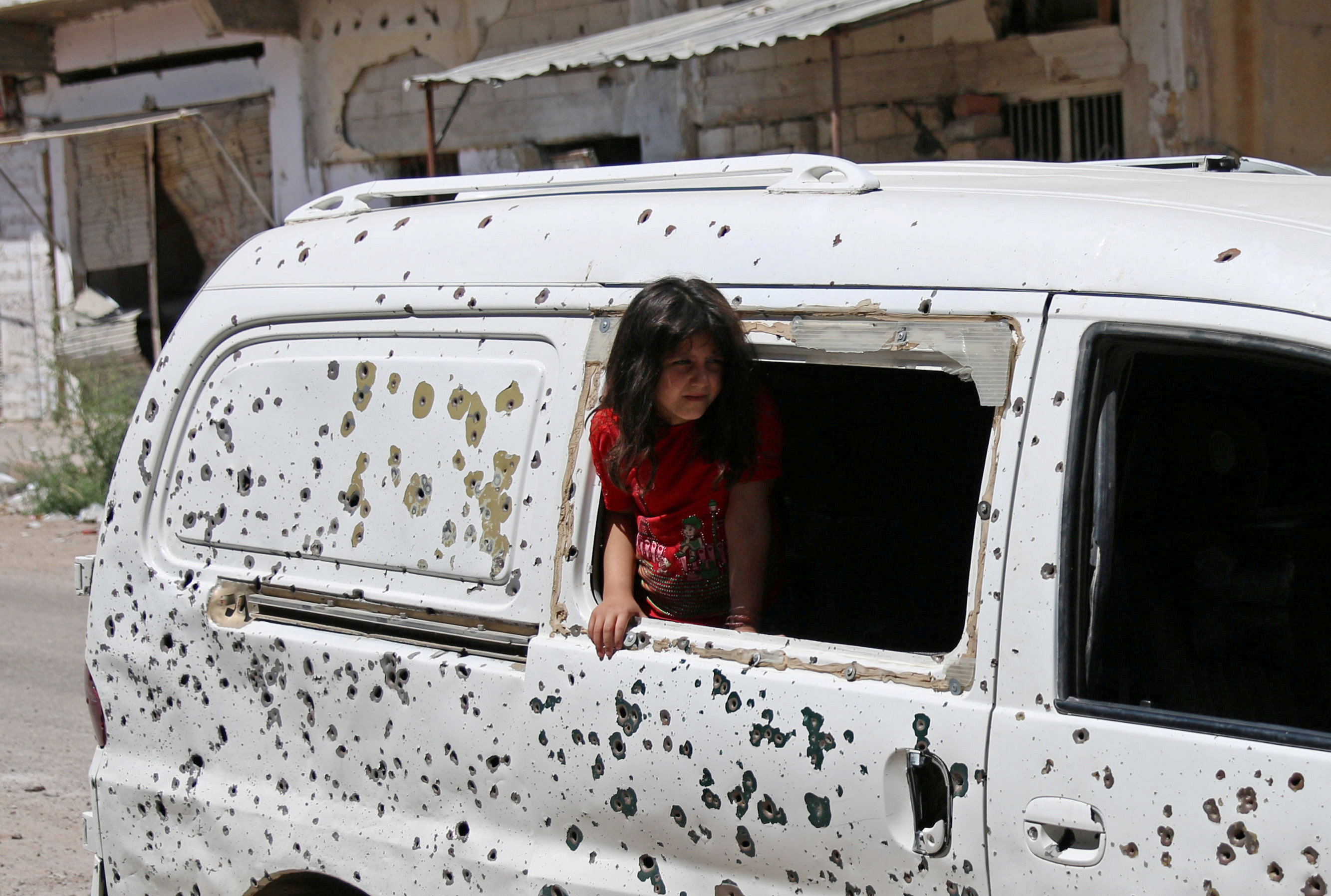 طفلة سورية تقف فى شباك سيارة متهشم
