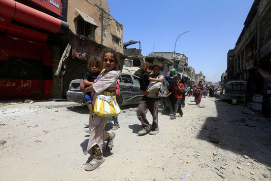 الأطفال يسيرون وسط ركام المنازل جراء الحرب فى الموصل
