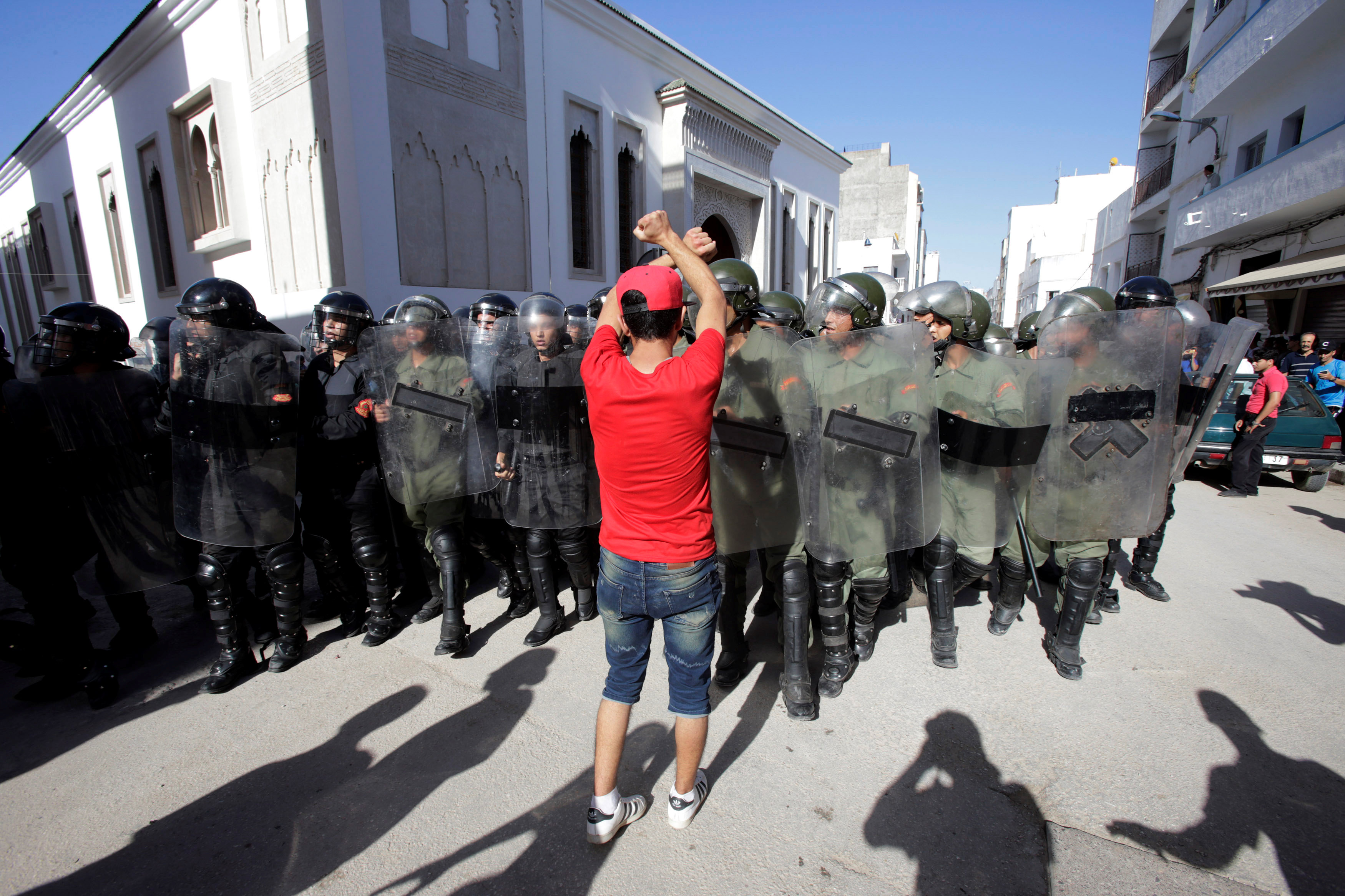 أحد المحتجين يقف أمام الشرطة المغربية