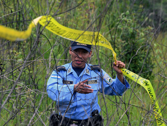 أحد عناصر الشرطة فى هندوراس خلال فرض طوقا أمنيا بمحيط المقبرة