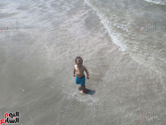 طفل يمرح على مياه الشاطئ فرحا بالمياه