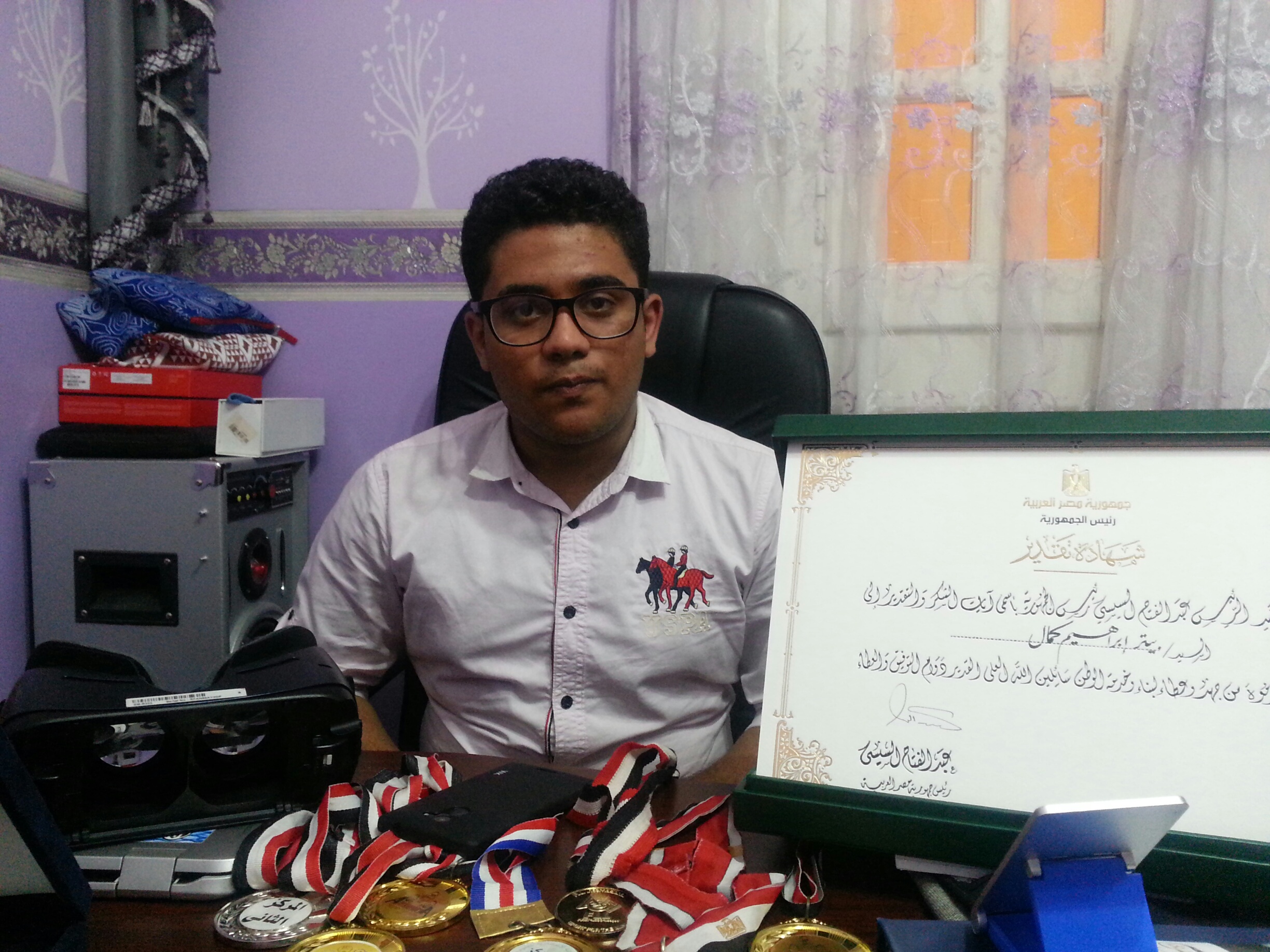 بيتر مع شهاداته وميدالياته