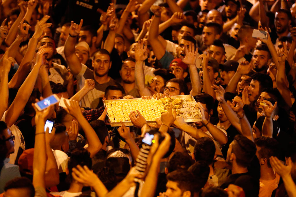 الفلسطينيون يحتفلون بتوزيع الكعك عقب تفوقهم على الاحتلال