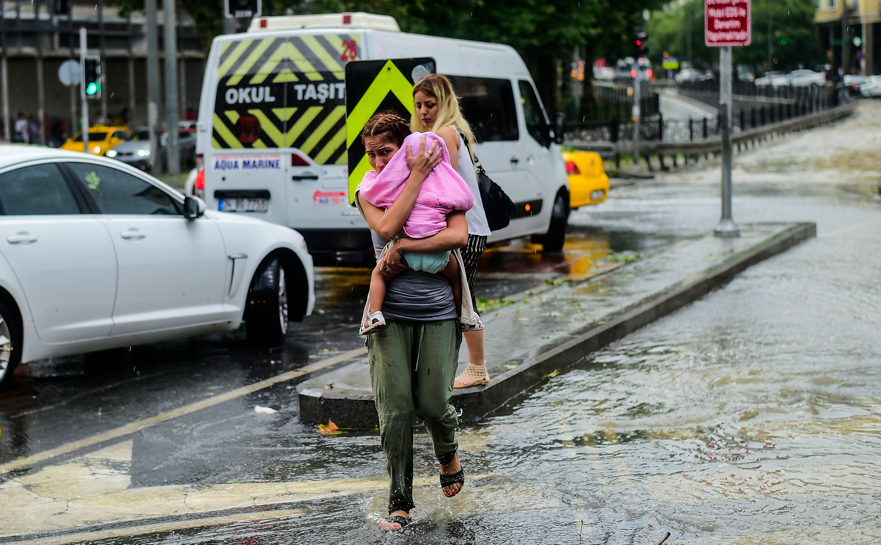 سيدة تحمى طفلها من الأمطار