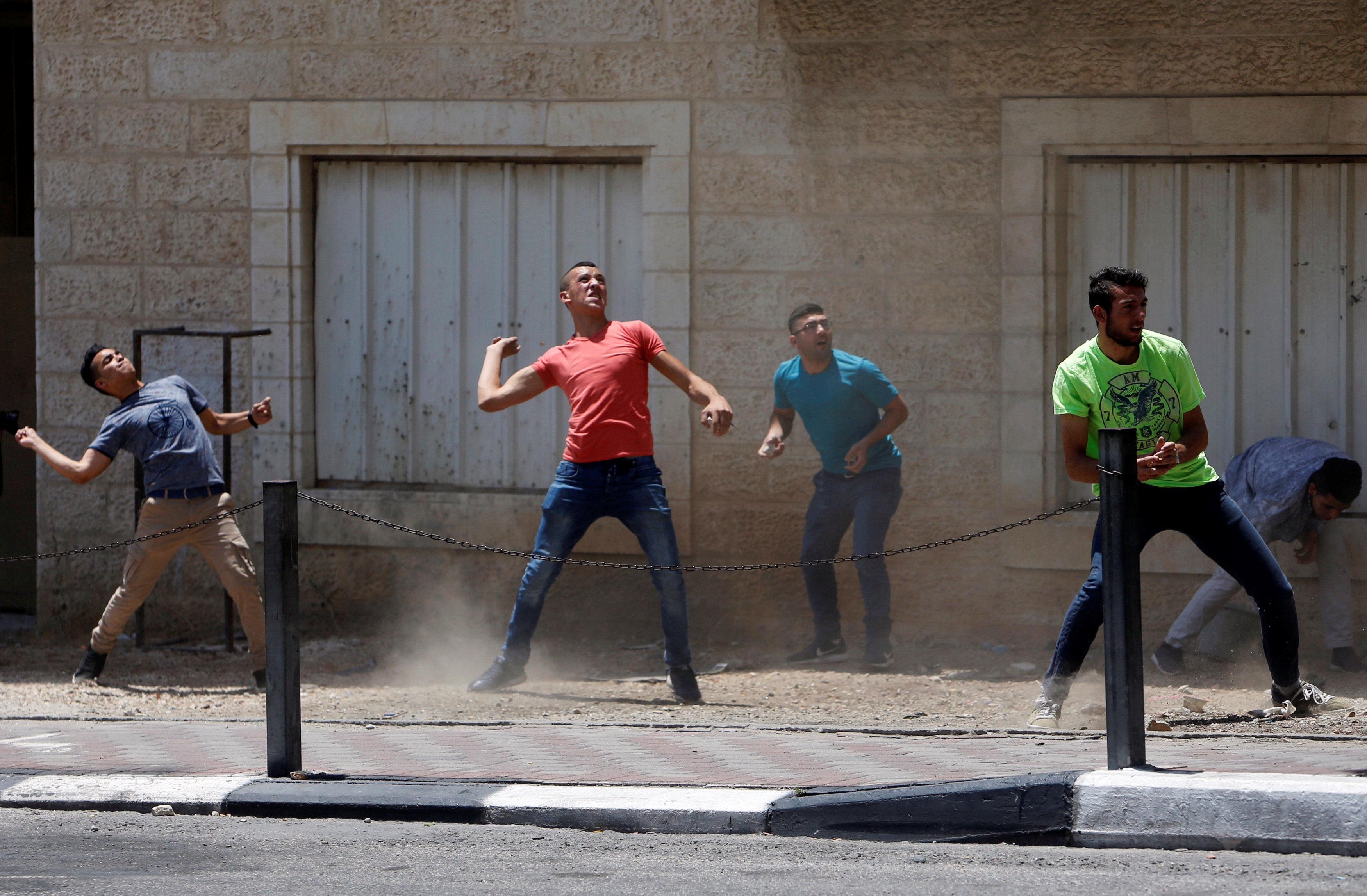 الشباب الفلسطينى يلقى الحجارة على قوات الاحتلال
