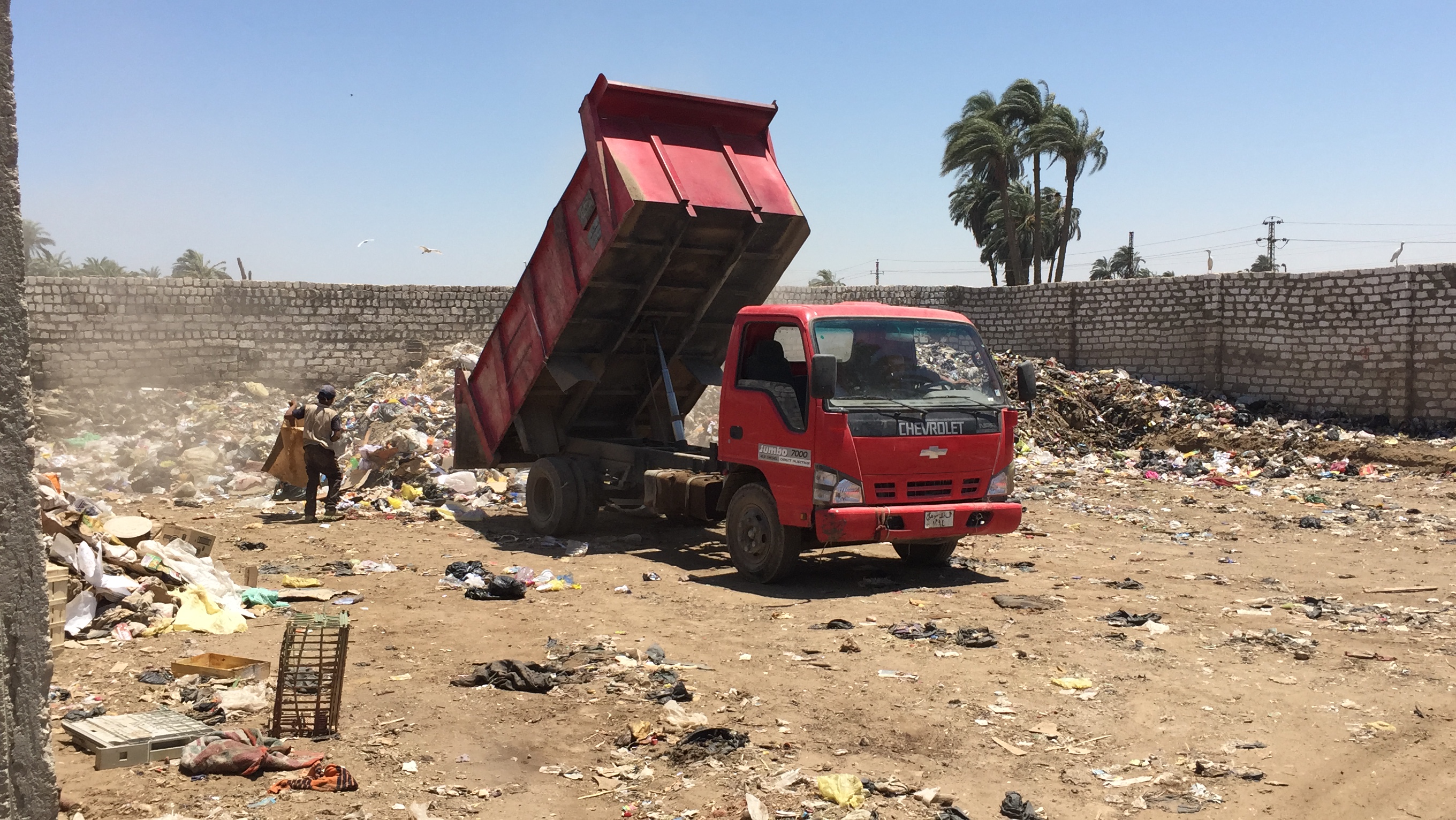 سيارة مجلس المدينة تقوم بإلقاء القمامة بجوار المساكن