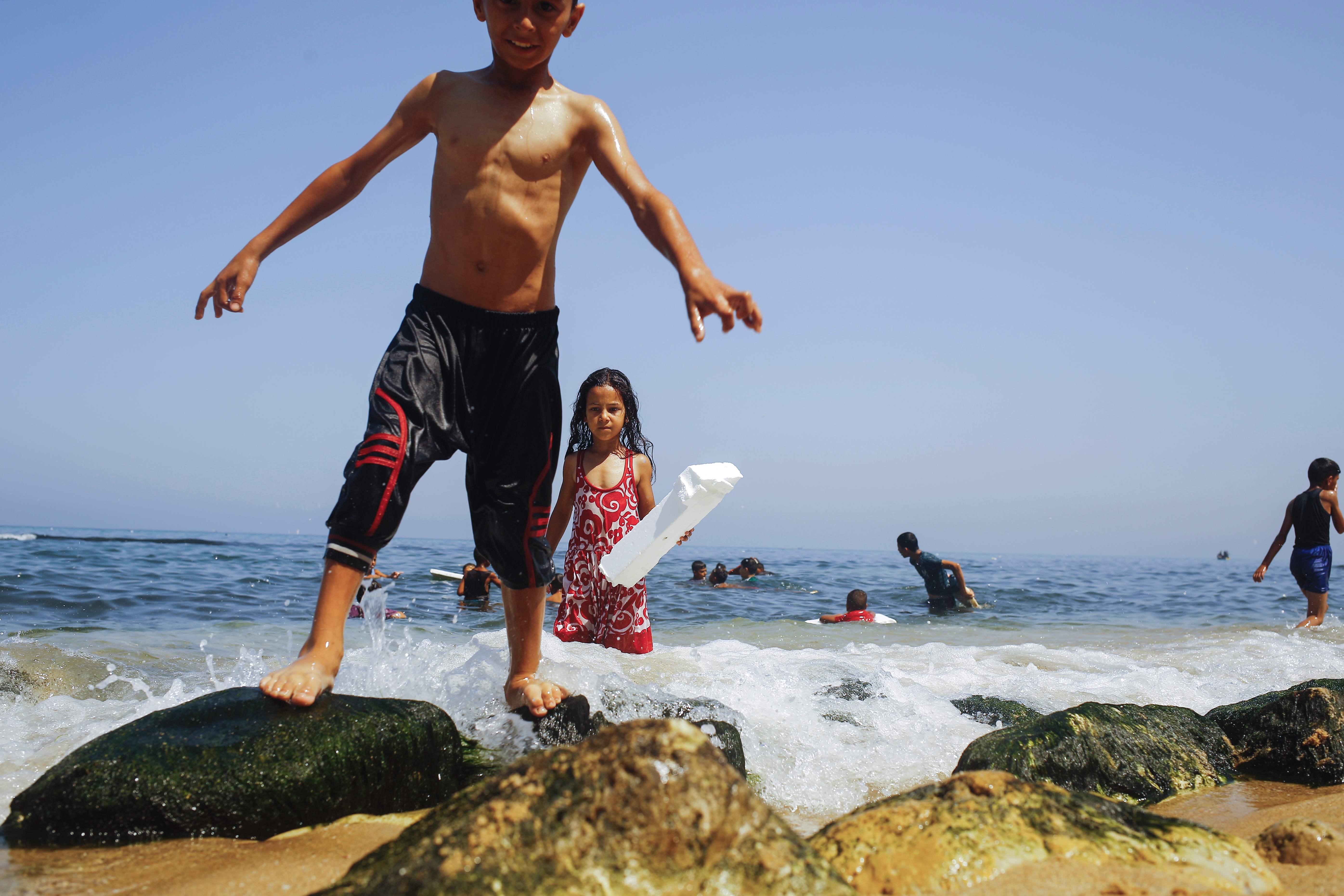 الأطفال يلعبون على صخور الشاطئ قرب غزة