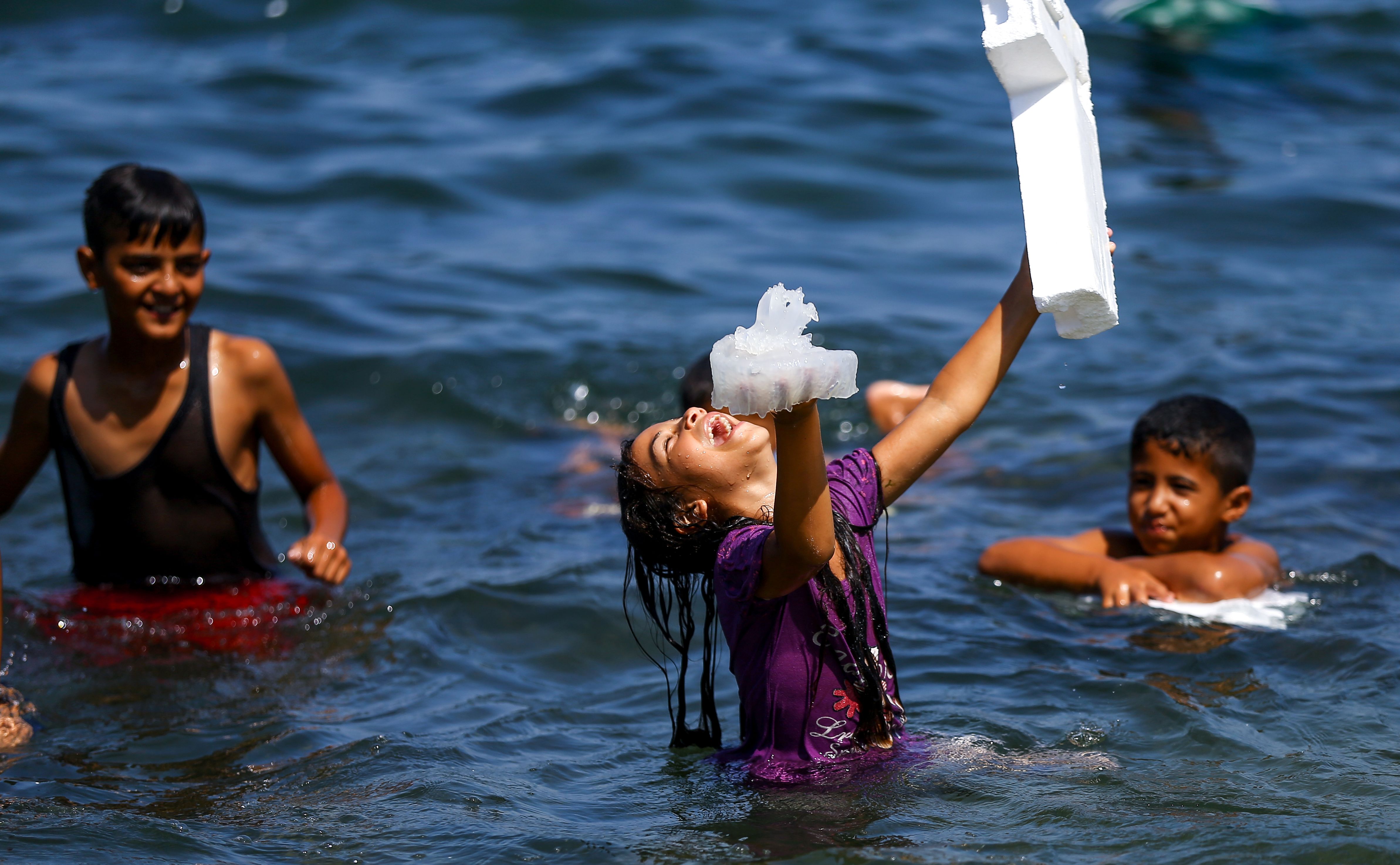 طفلة فلسطينية تضحك وتمسك قنديل البحر فى يدها
