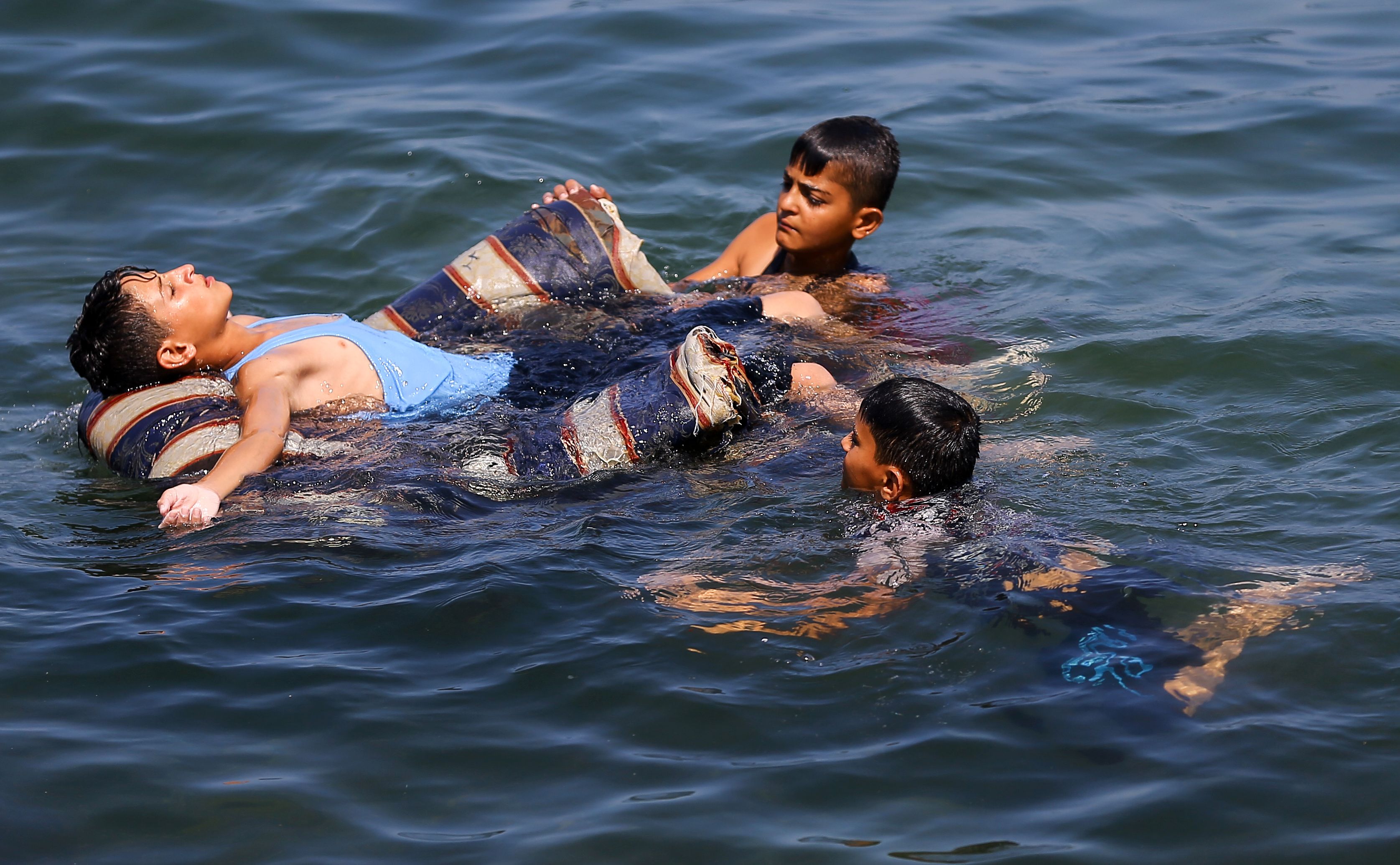 الأطفال الفلسطينيون يسبحون على شواطئ البحر المتوسط