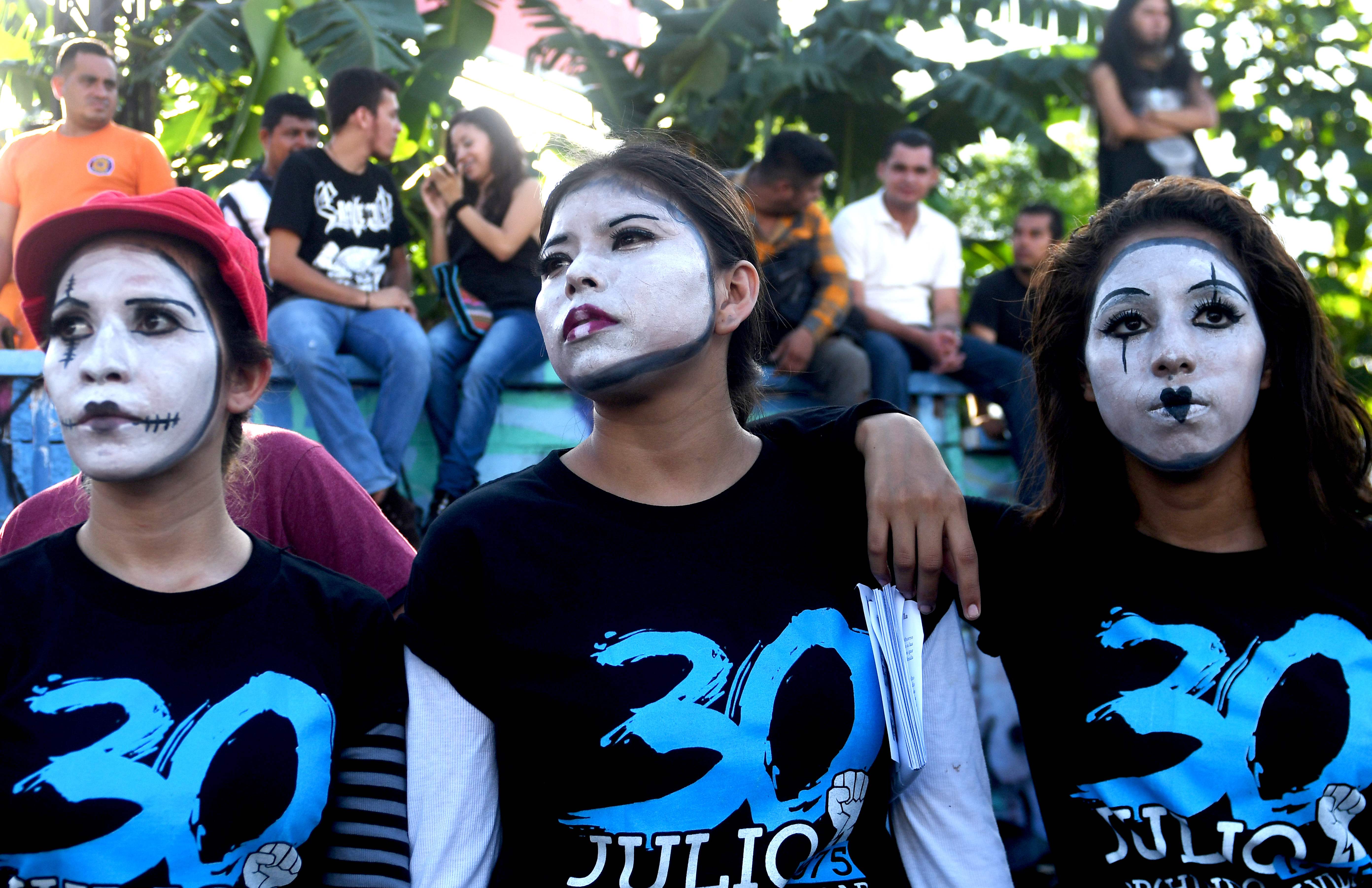متظاهرون يرسمون وجوههم خلال مسيرة فى السلفادور