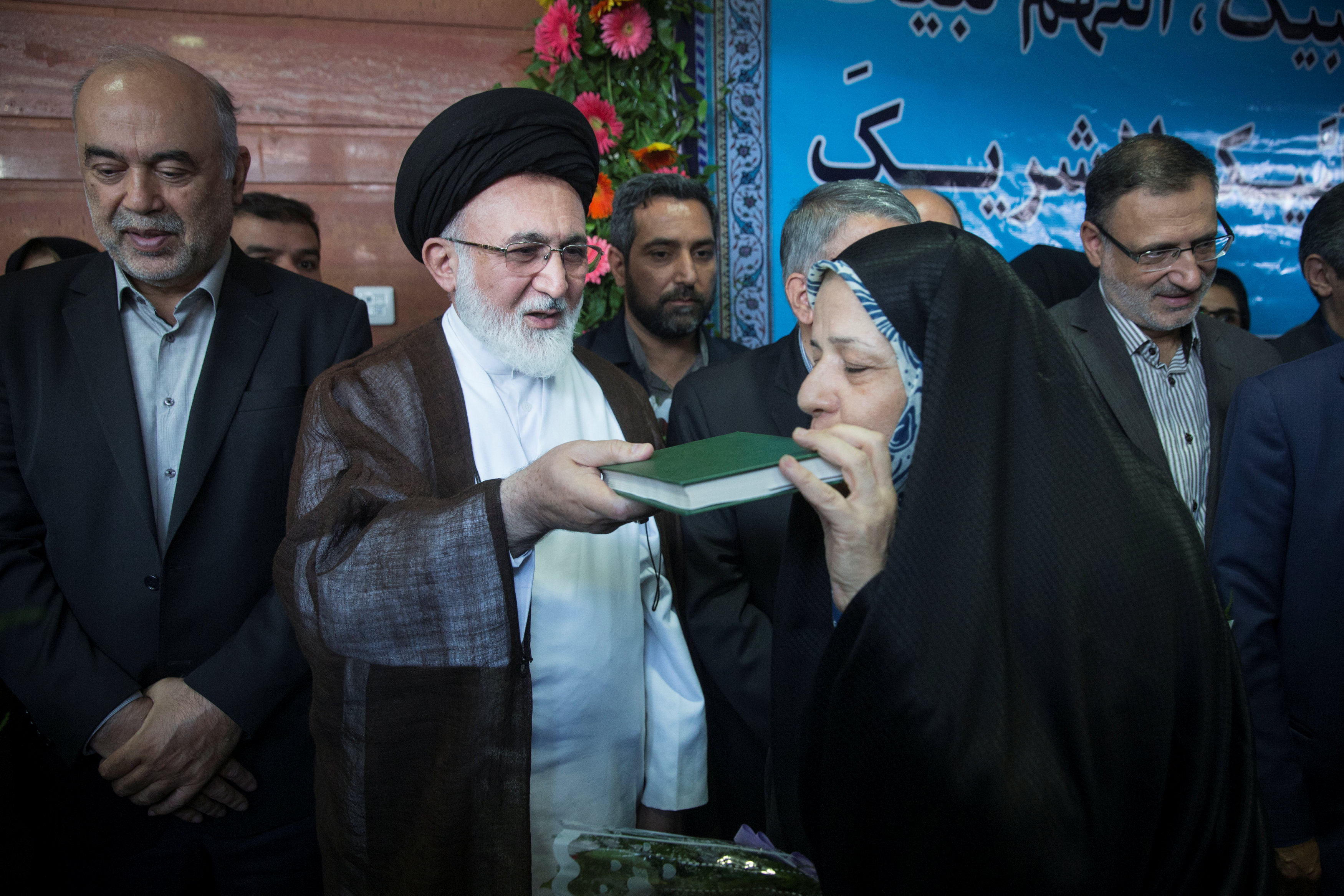 الحجاج الإيرانيين يقبلون المصحف الشريف قبل مغادرة بلادهم