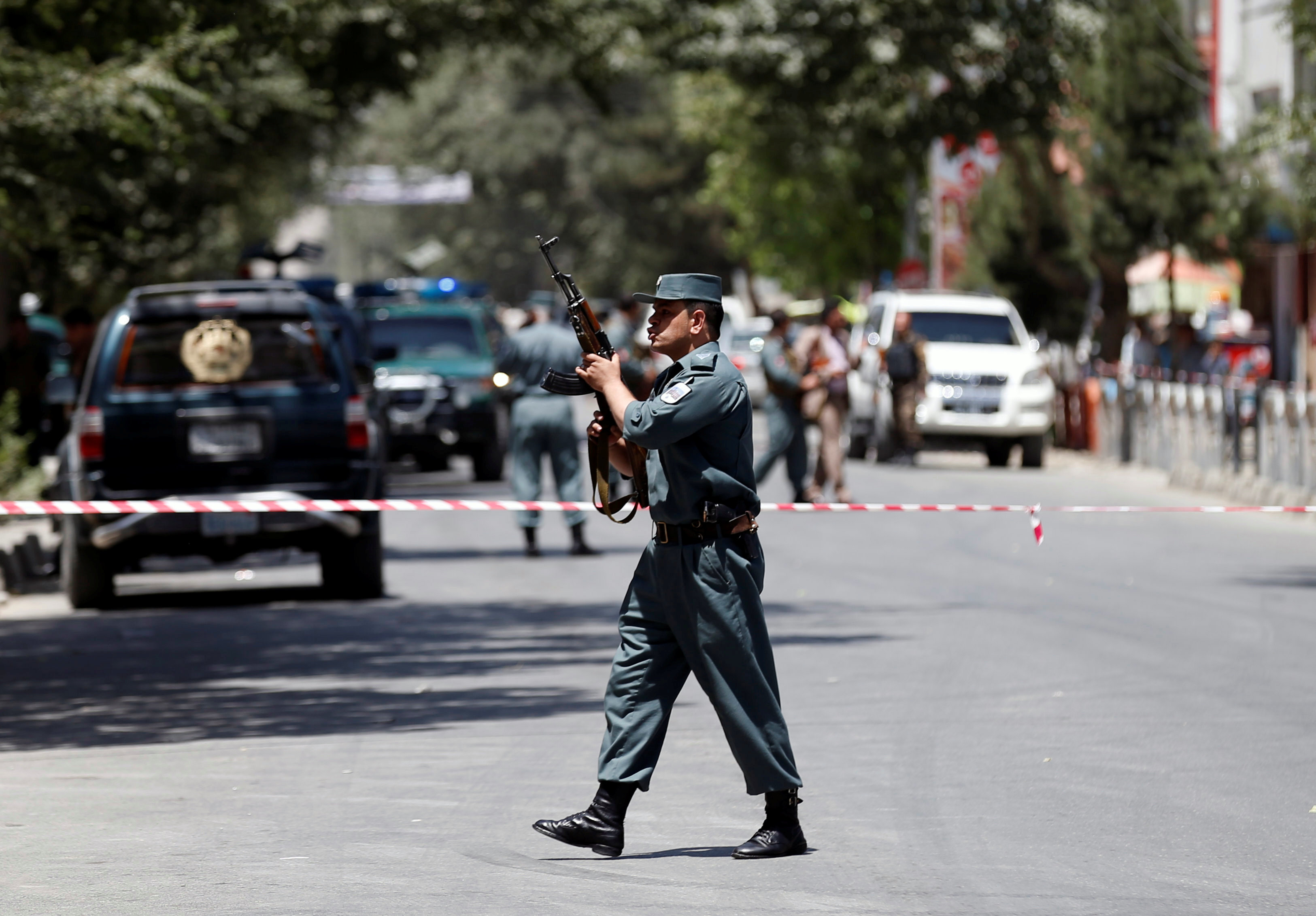 شرطى أفغانى يقف أمام حاجز بمحيط التفجير الإرهابى