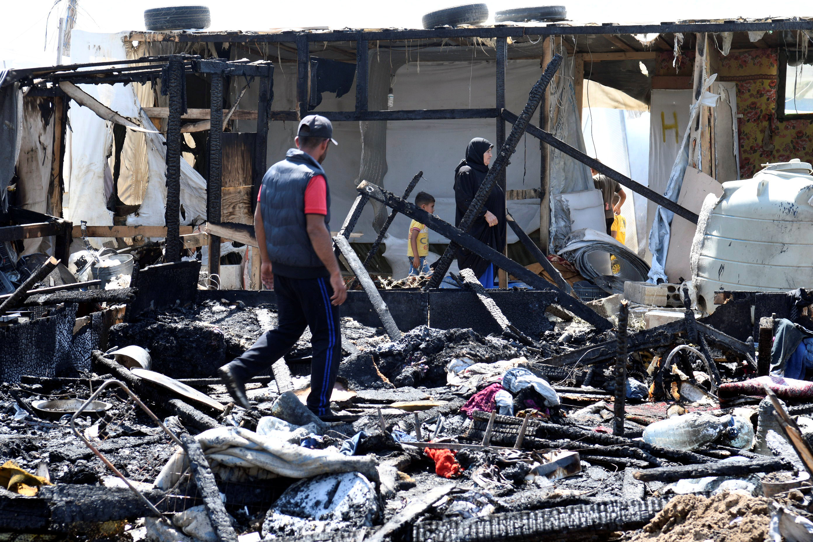 أثار الحطام وحريق مخيم اللاجئين السوريين
