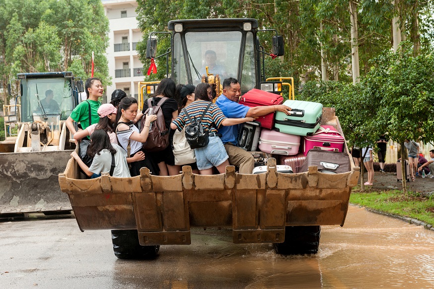 مواطنون صينيين يستخدمون جرار للهروب من الفيضانات