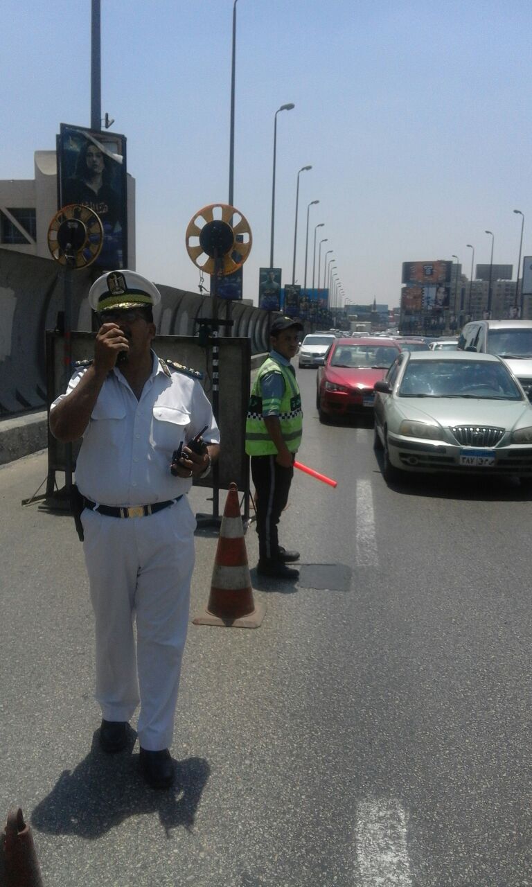 رجال المرور يتابعون الحركة المرورية أعلى الكوبرى