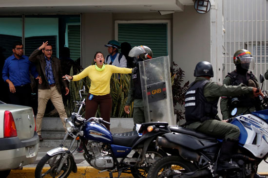 فتاة تواجه الشرطة الفنزويلية