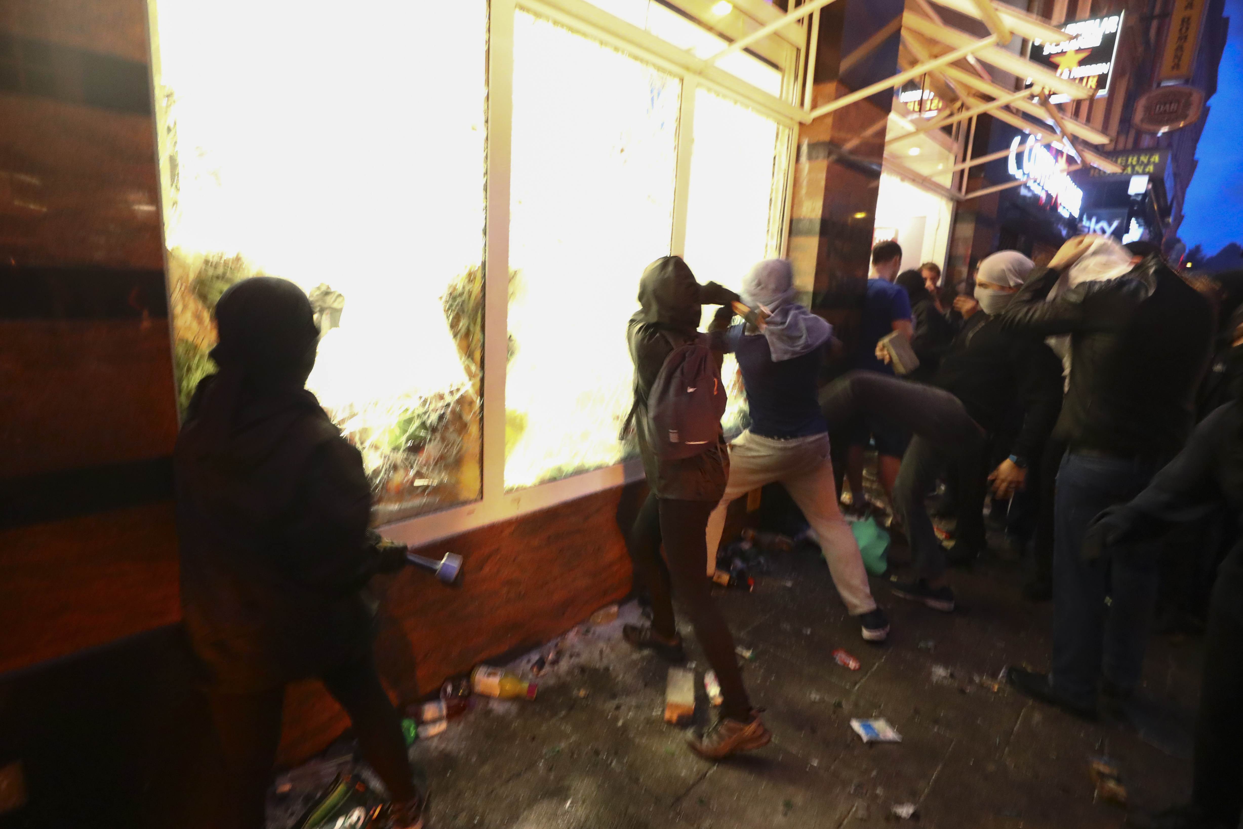المتظاهرون يهاجمون أحد المتاجر ويحطمون الزجاج الخارجى