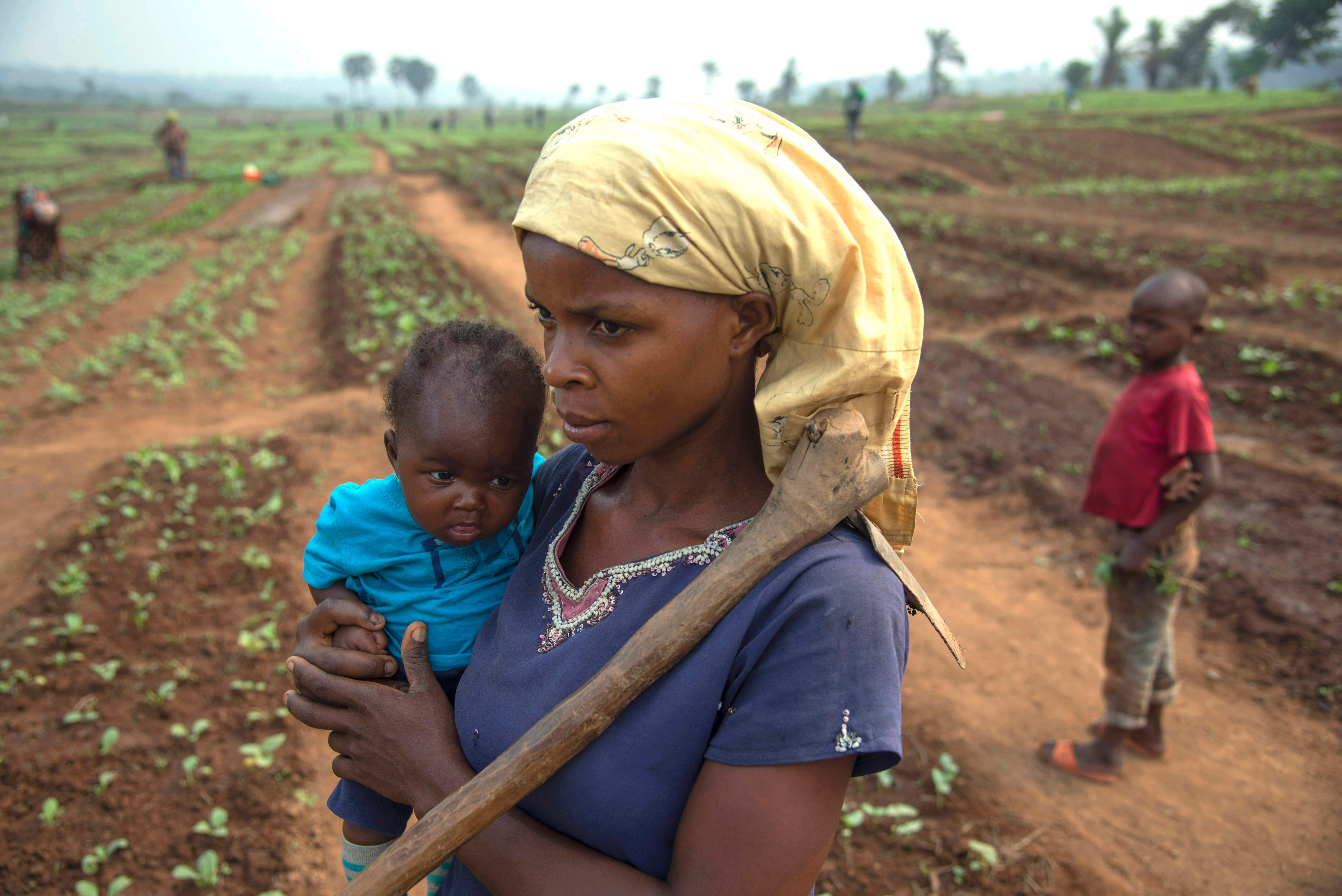 سيدة تحمل طفلها أثناء العمل فى الزراعة بالكونغو