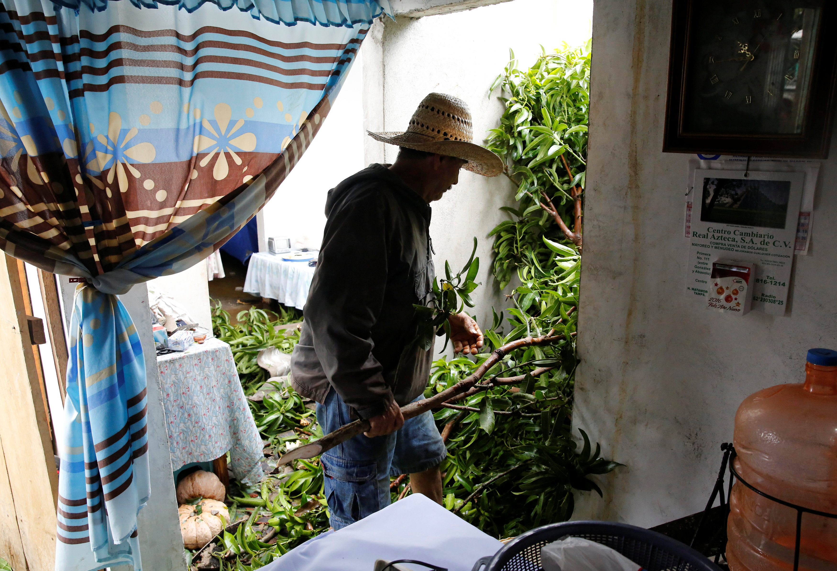 رجل ينظف منزله من آثار العاصفة