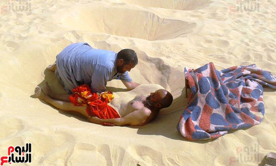 بداية عملية دفن احد المرضى للعلاج بحمام الرمال