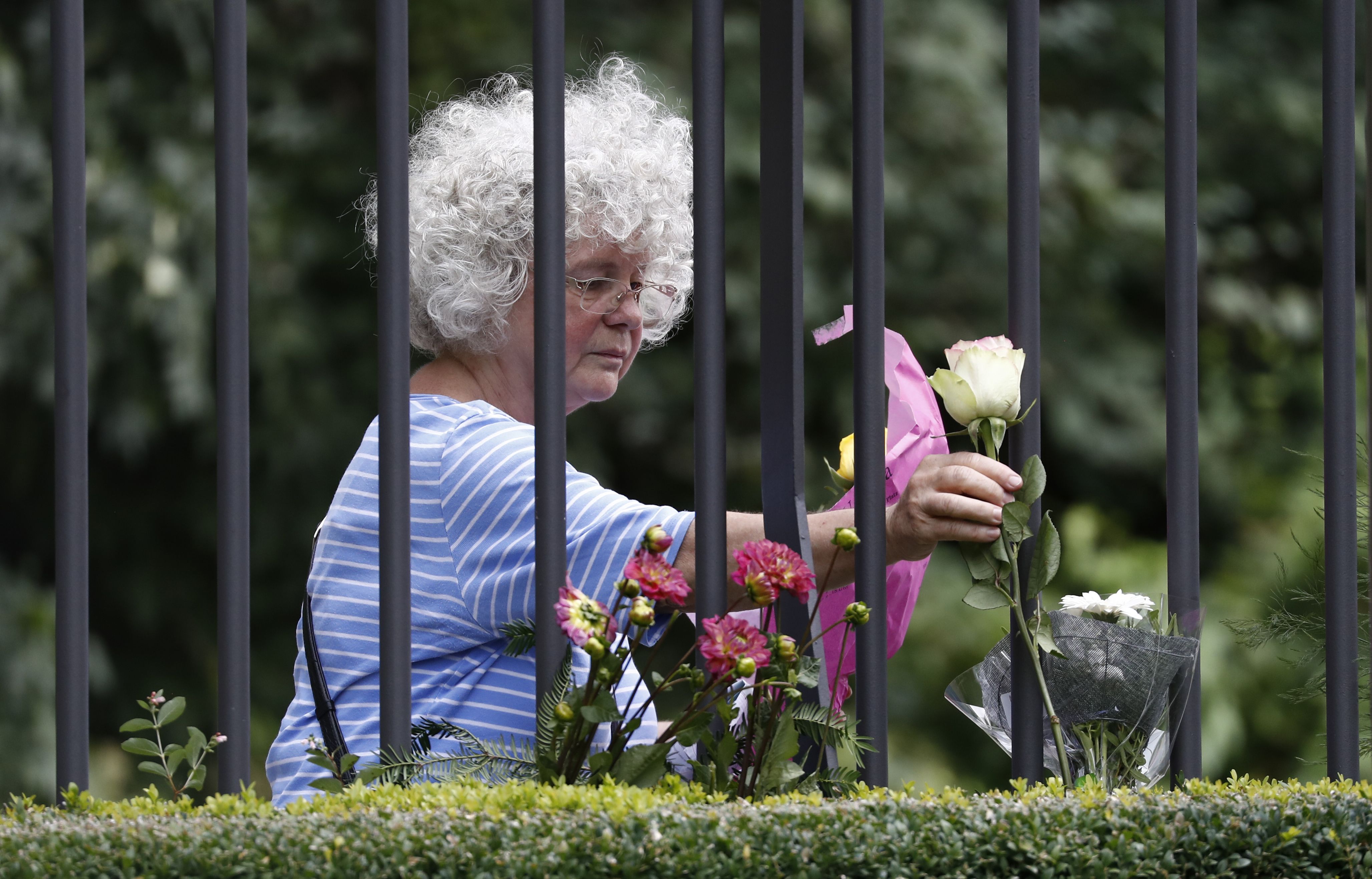 سيدة مسنة تضع الورود فى مكان الحادث