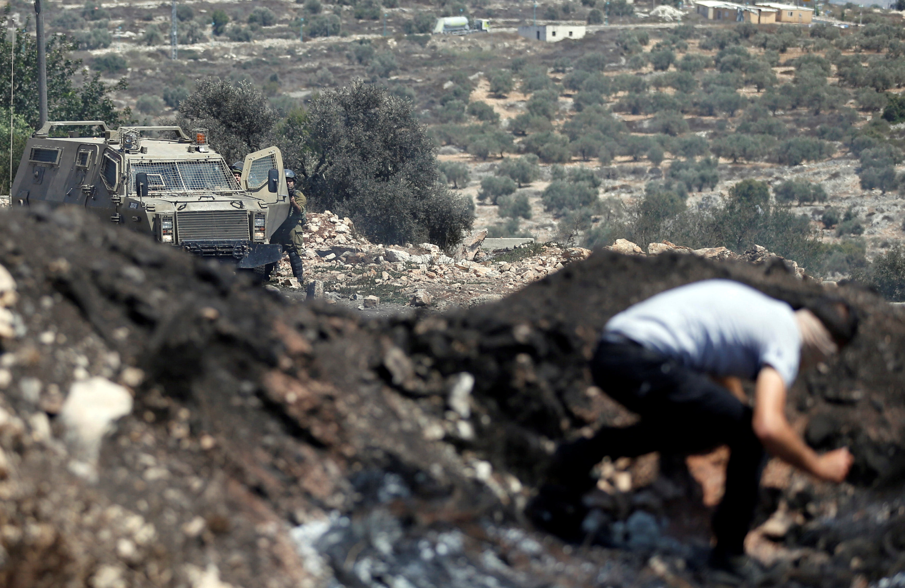 مناضل فلسطينى يختبئ من طلقات رصاص الاحتلال الاسرائيلى