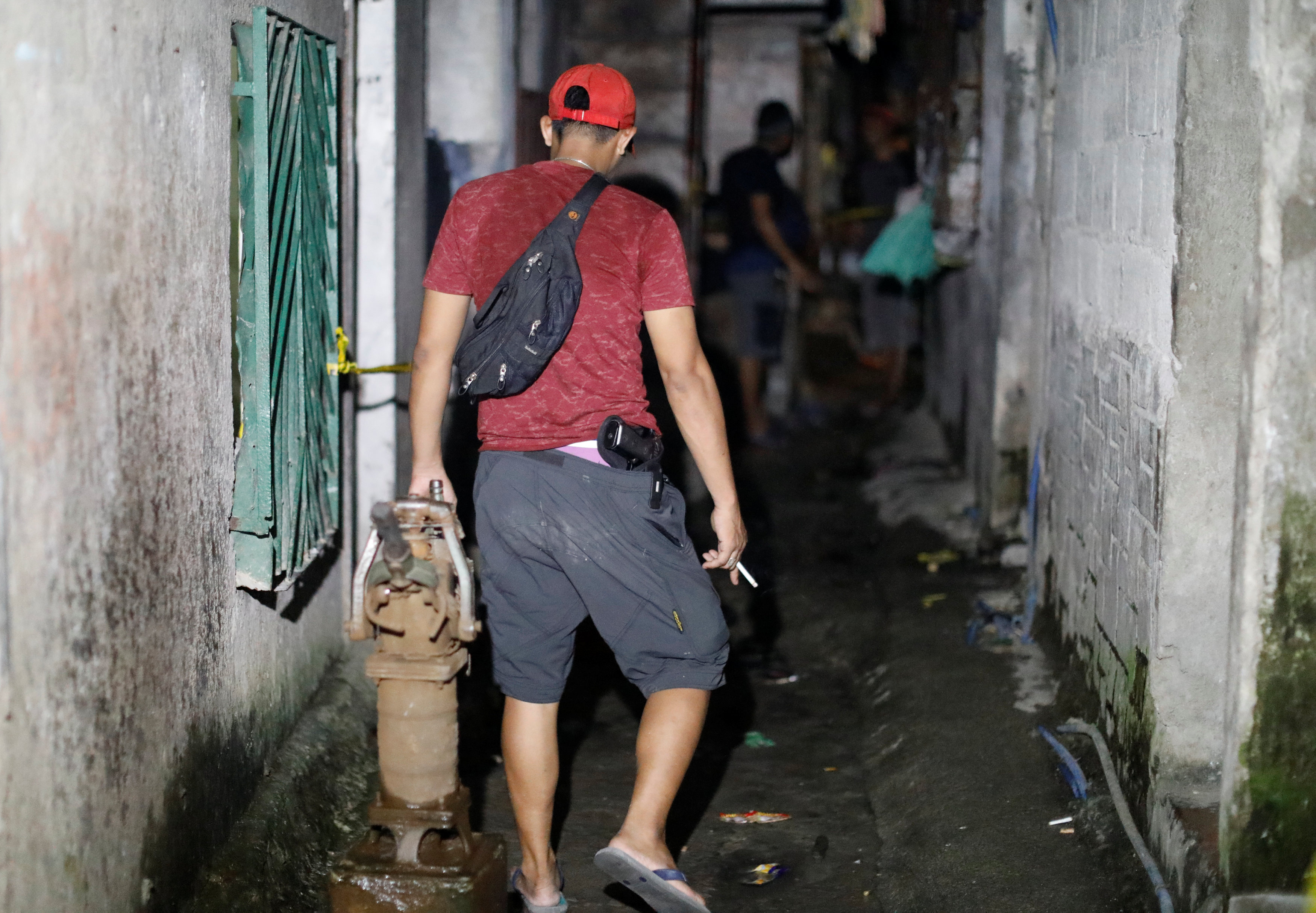 أحد أفراد الشرطة الفلبينية بزى مدنى يسير وسط البيت