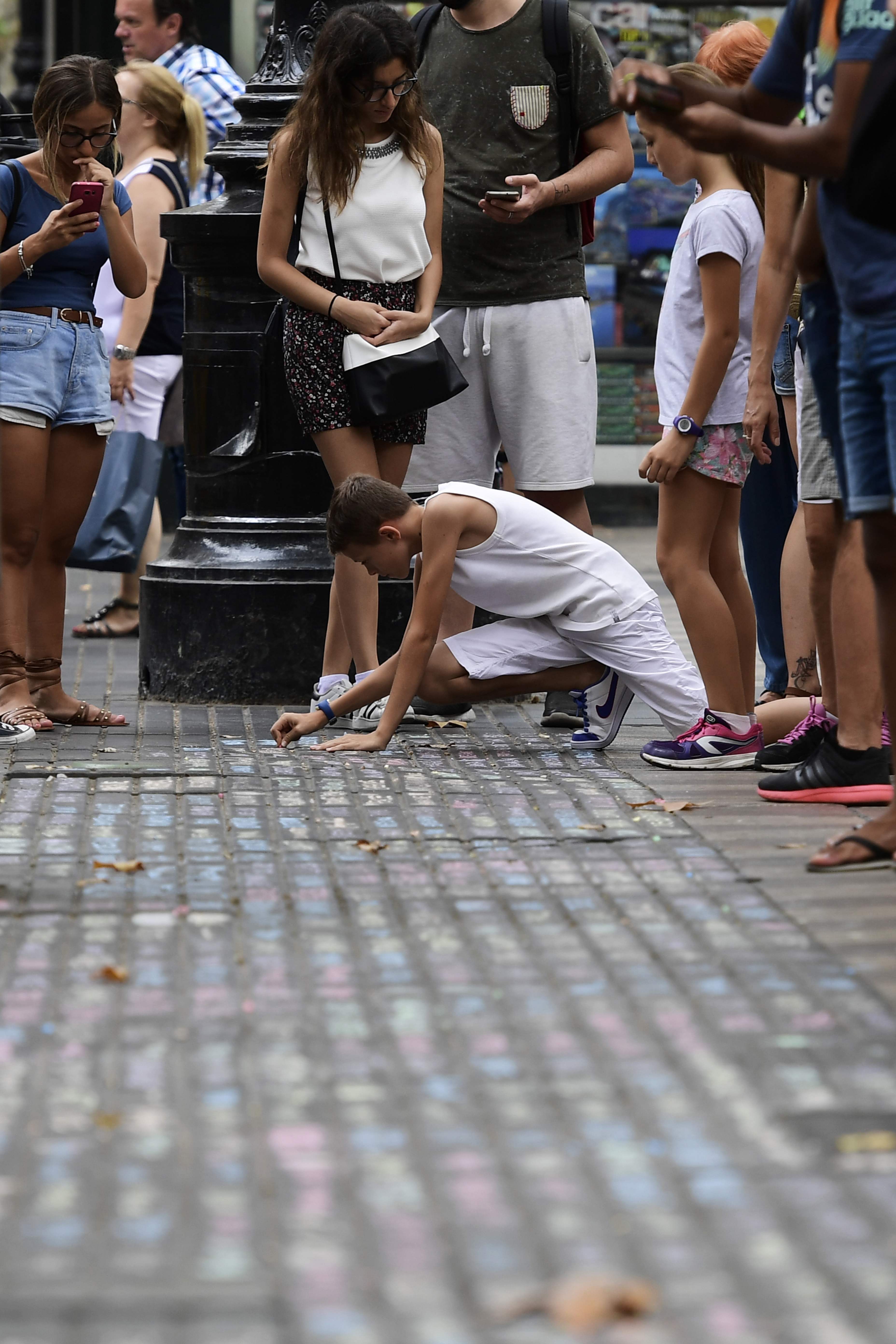 فتاة تكتب رسالة تعزية على الأرض فى ضحايا الإرهاب