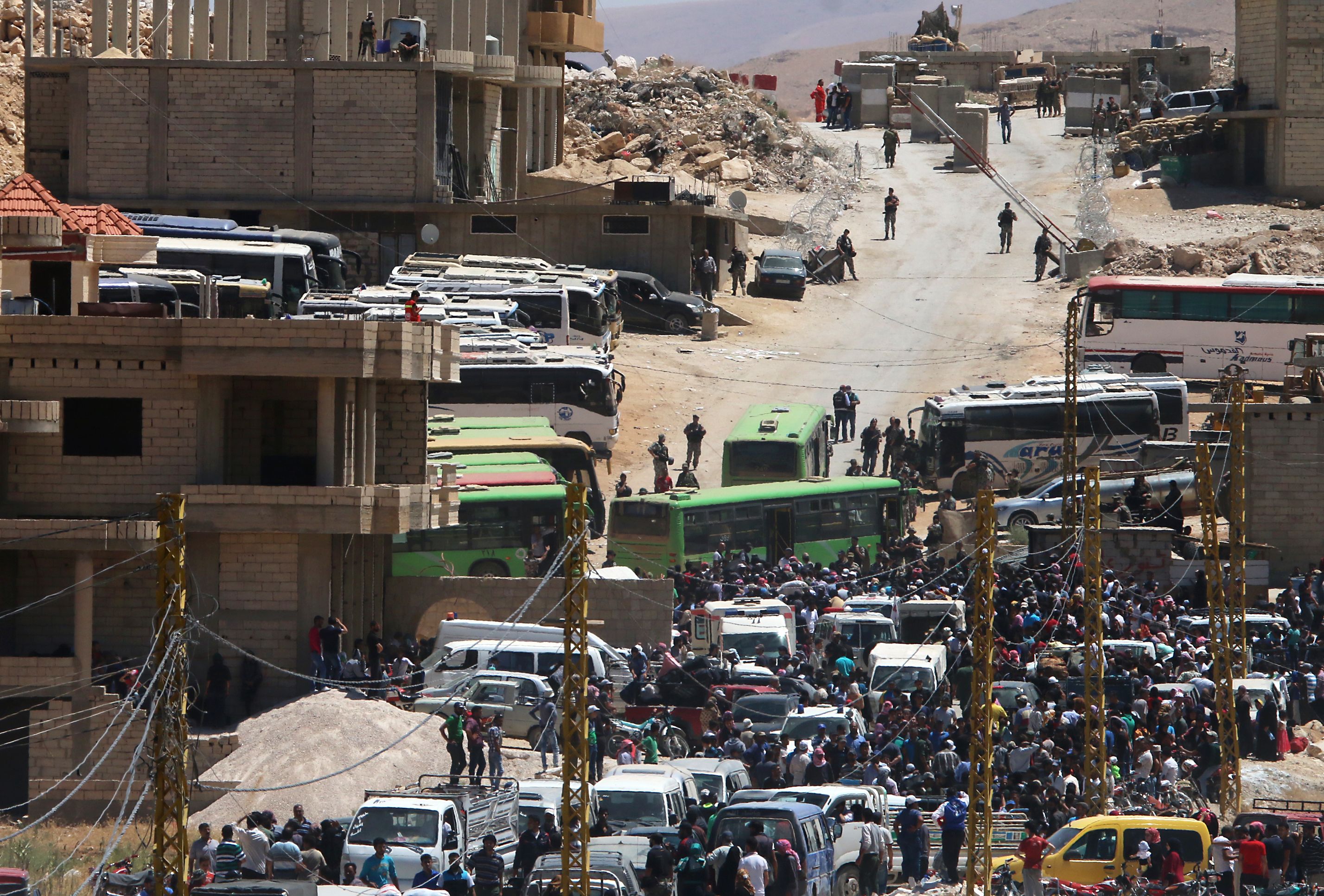 تجمع اللاجئون السوريون حول حافلات متجهة إلى مدينة إدلب السورية