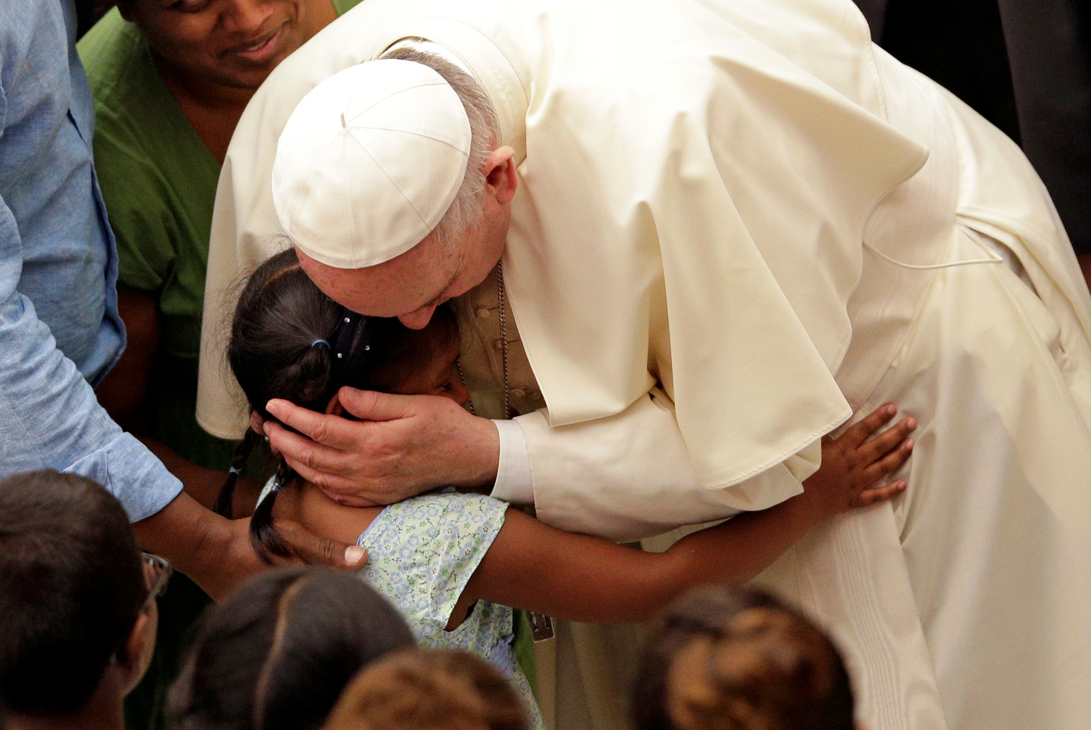 البابا فرانسيس يعانق طفلة