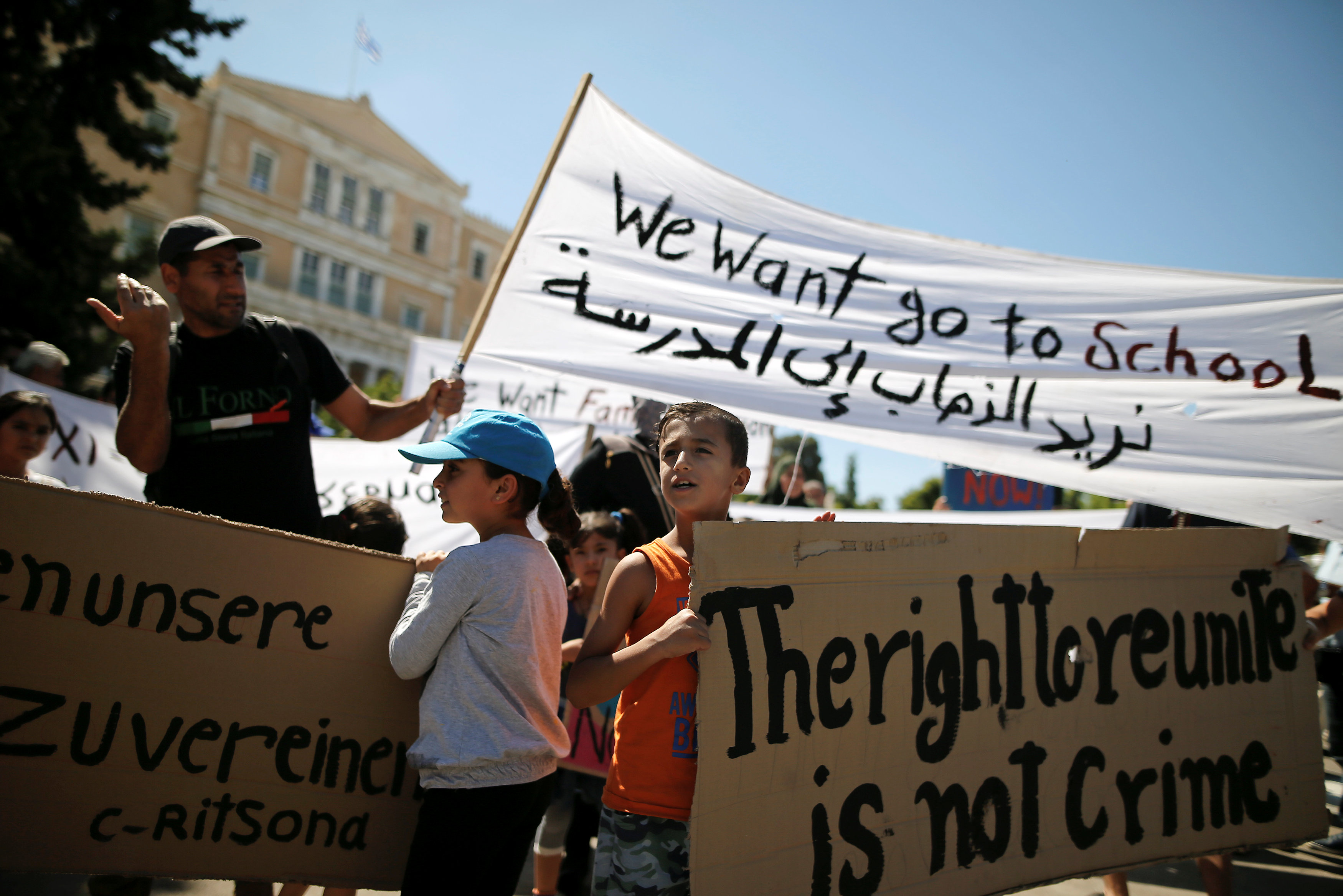 أطفال سوريون يحملون اللافتات