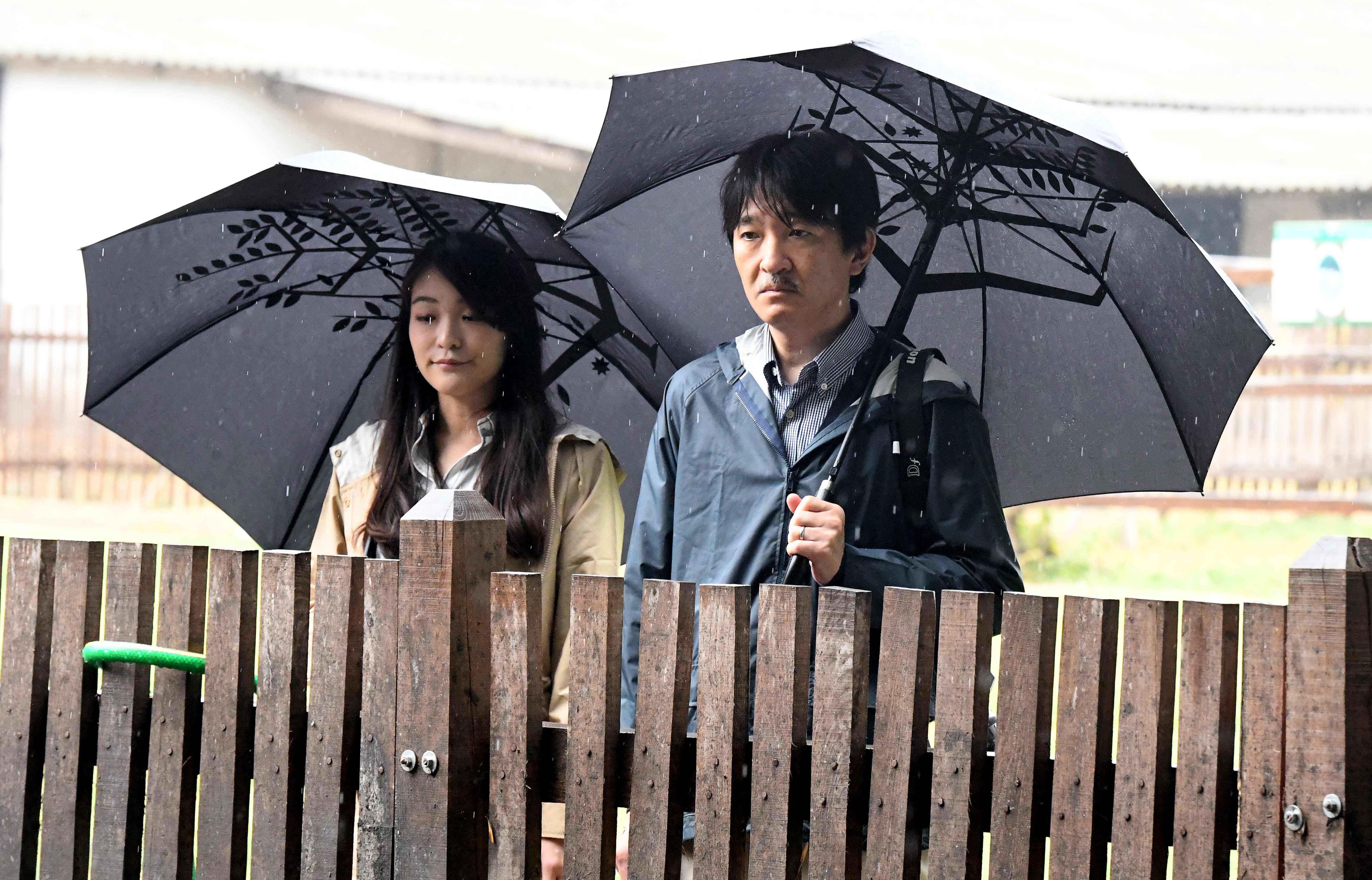 الأمير أكيشينو وأميرة موكا يحملان المظلات خلال جولتهما بالمجر