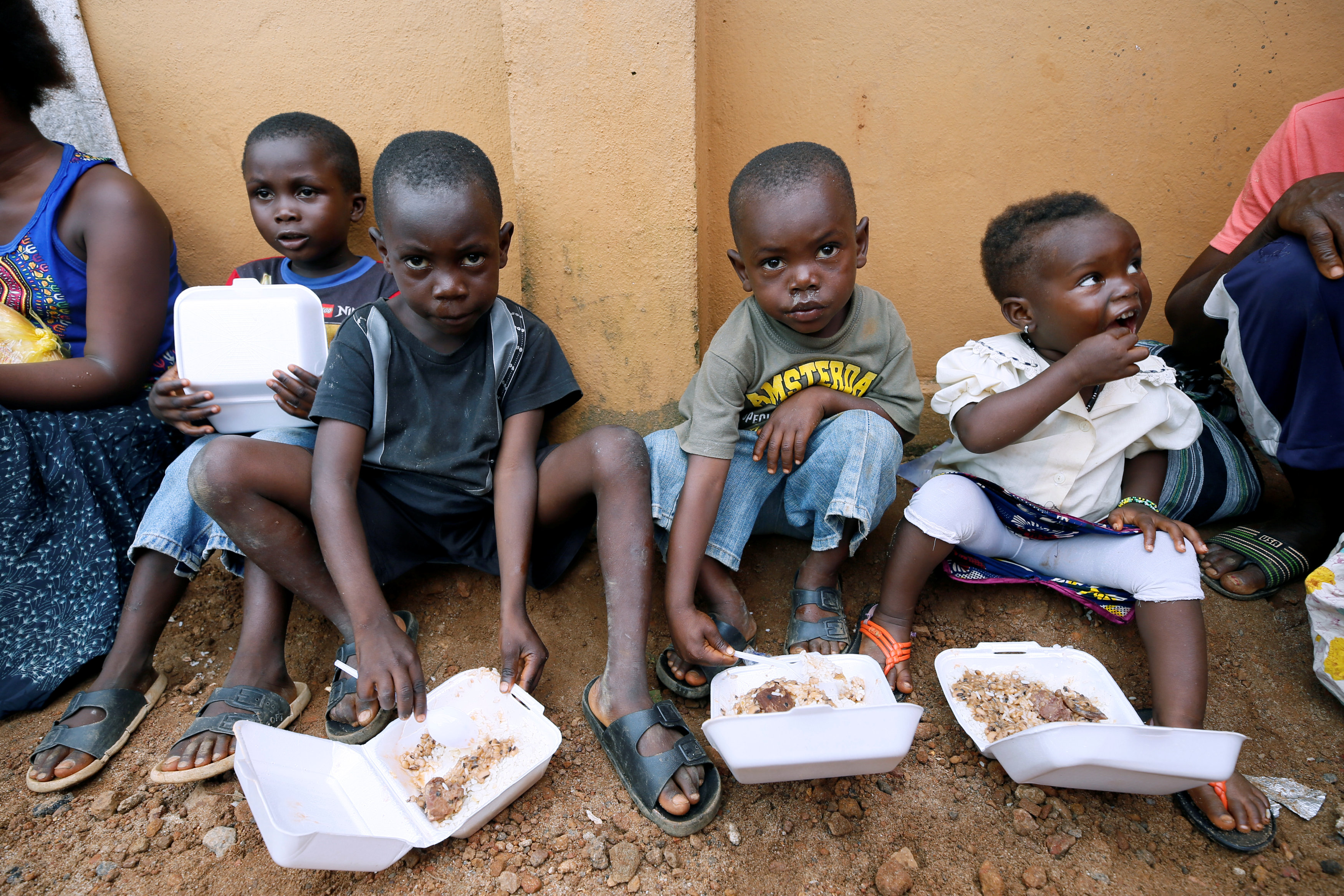 أطفال يتناولون وجبة الغداء الموزعة من منظمة غير حكومية