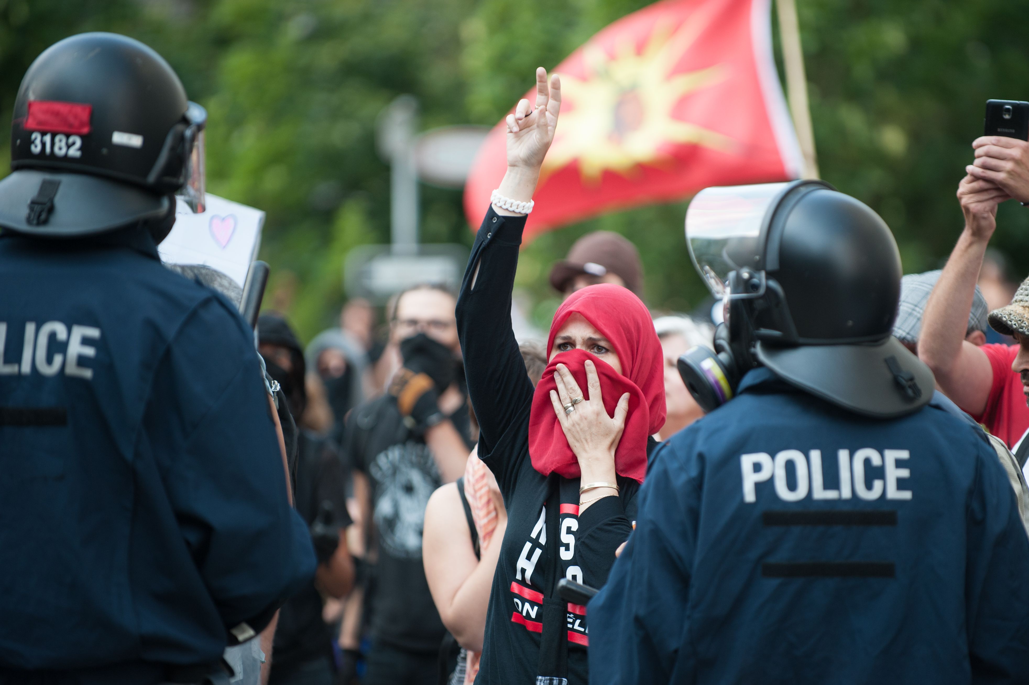 سيدة مؤيدة للهجرة تقف أمام قوات الأمن الكندية