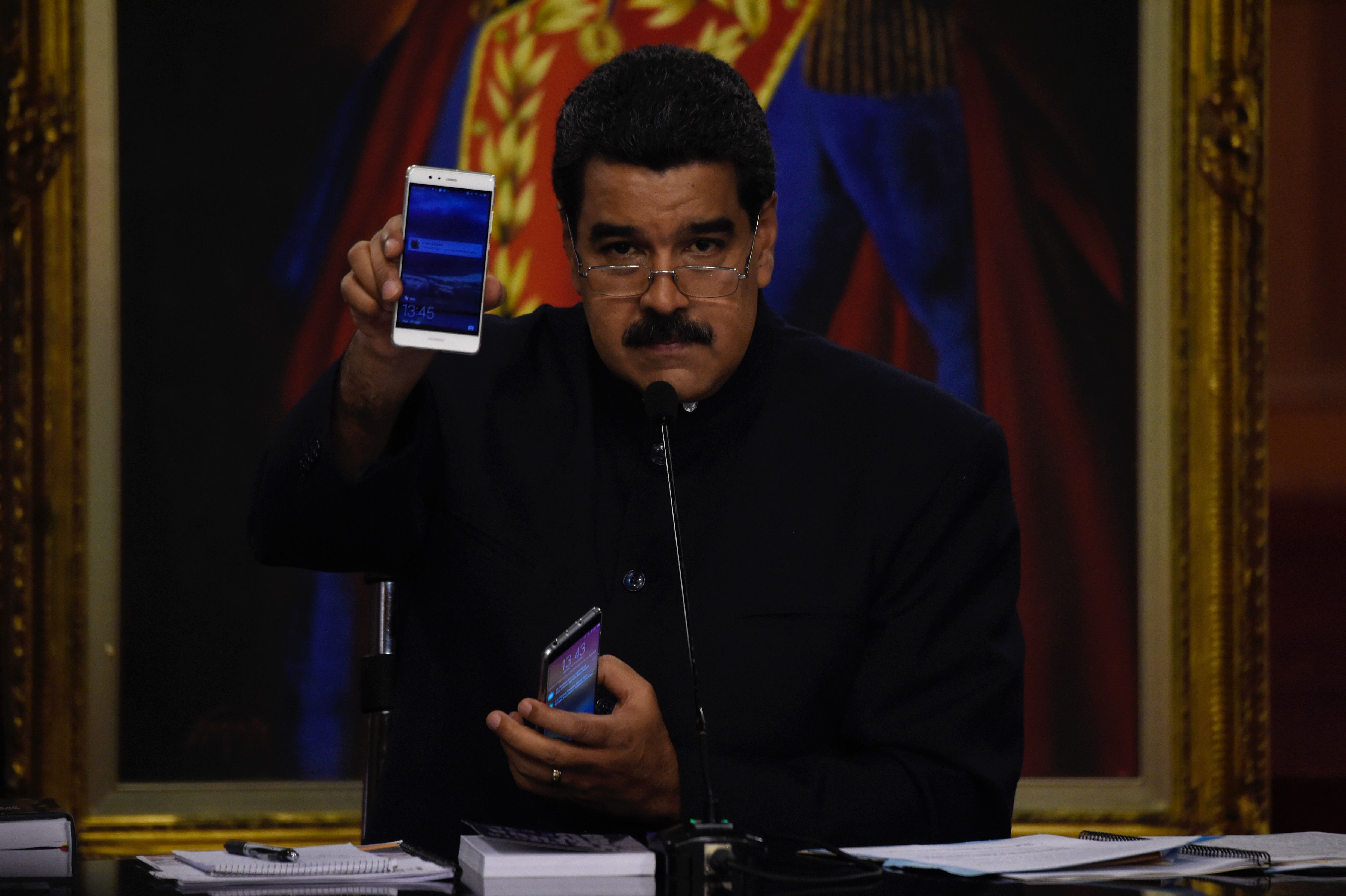 نيكولاس مادورو يشير بهاتفه