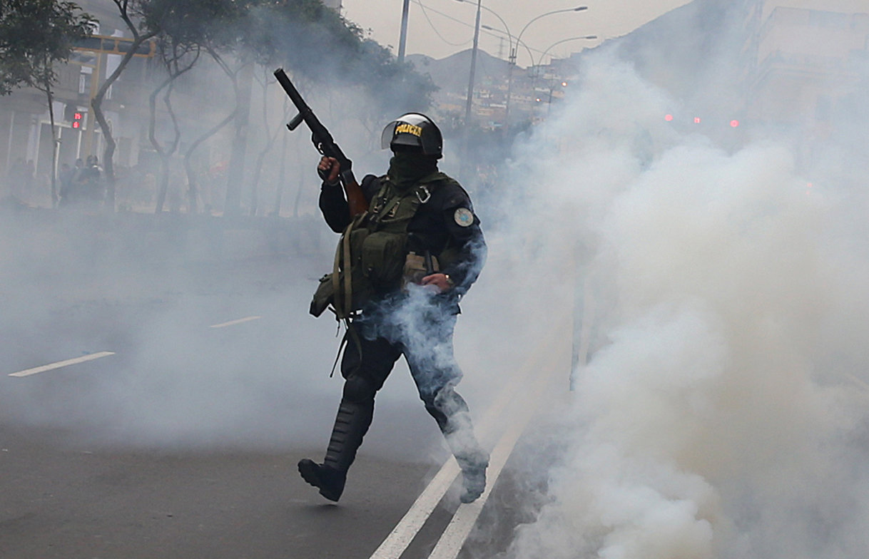 أحد عناصر الشرطة يطلق الغاز المسيل للدموع