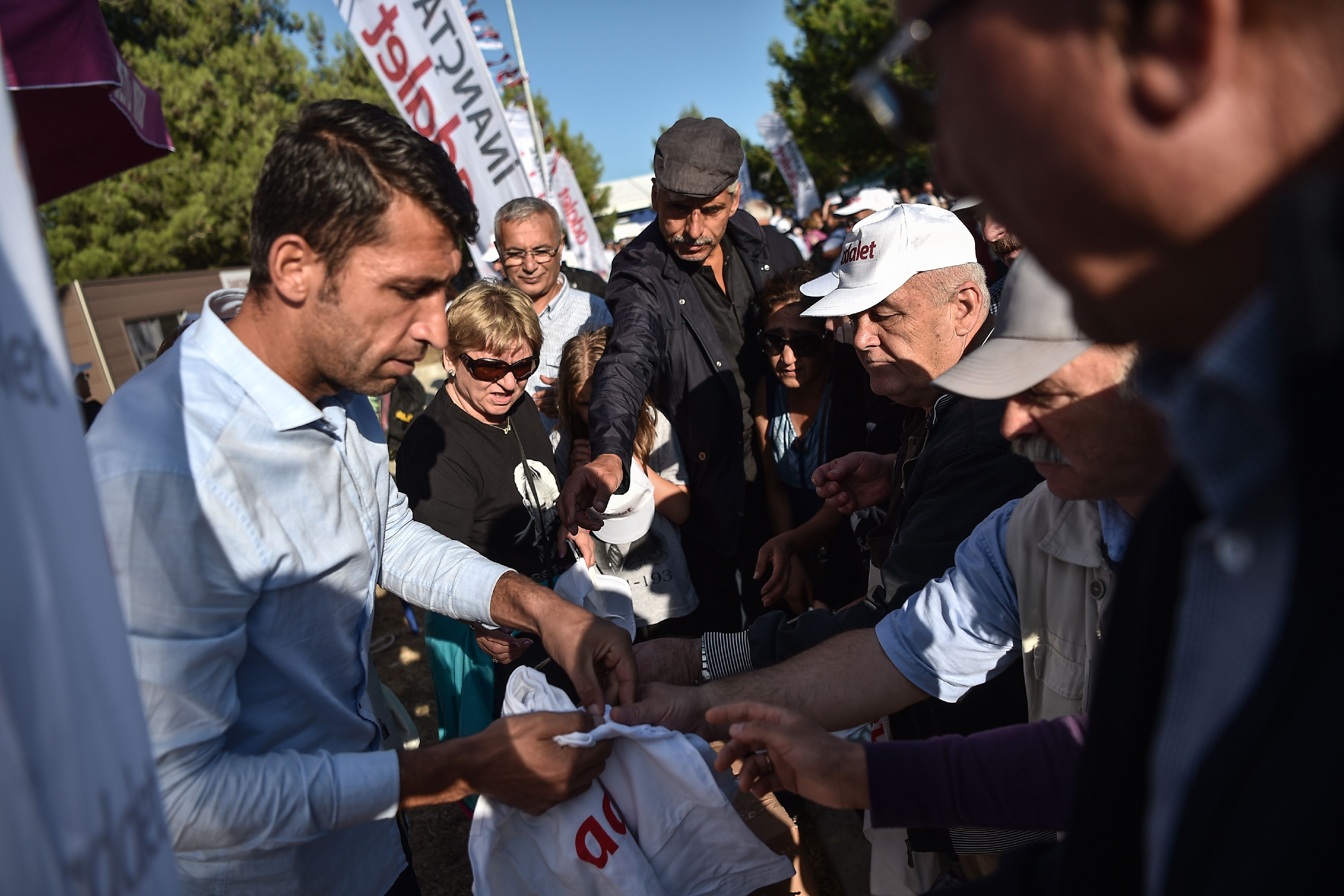 شاب يوزع تى شيرتات موحدة على المشاركين فى مؤتمر المعارضة التركية
