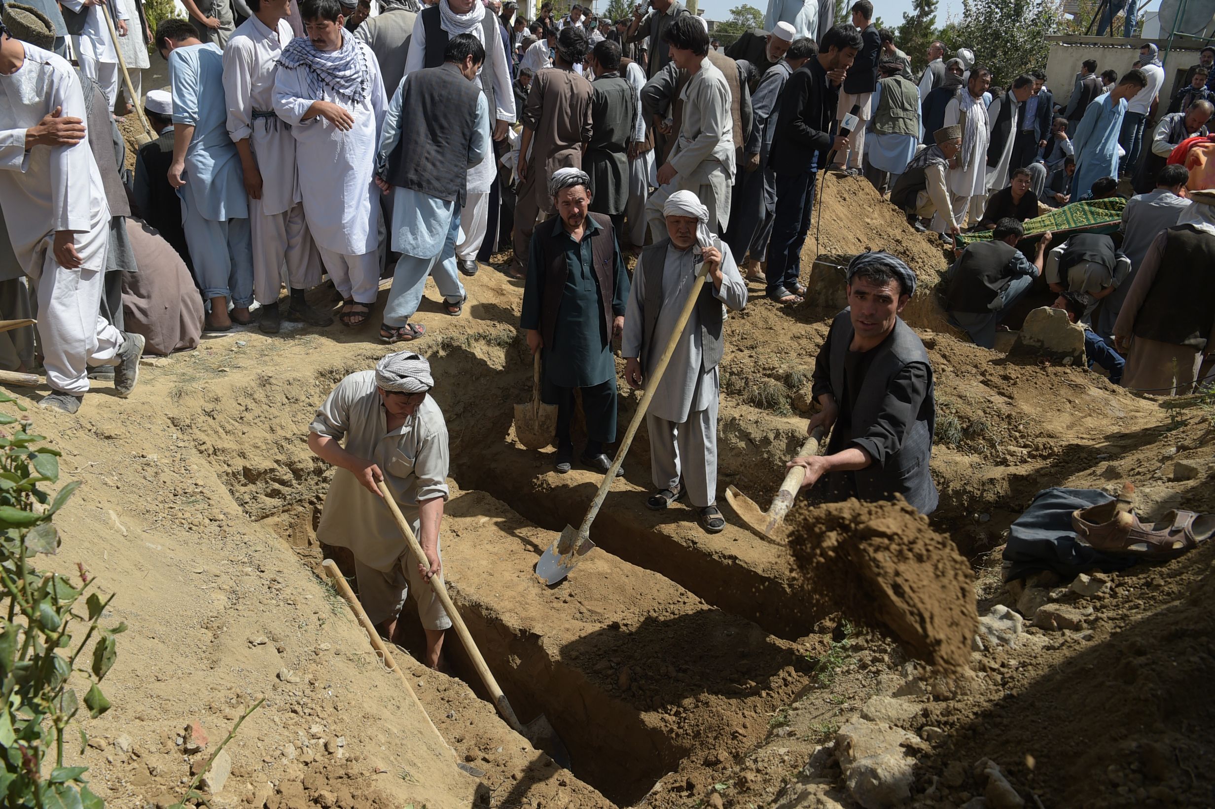 الأفغان يحفرون القبور لضحايا الهجوم الانتحارى