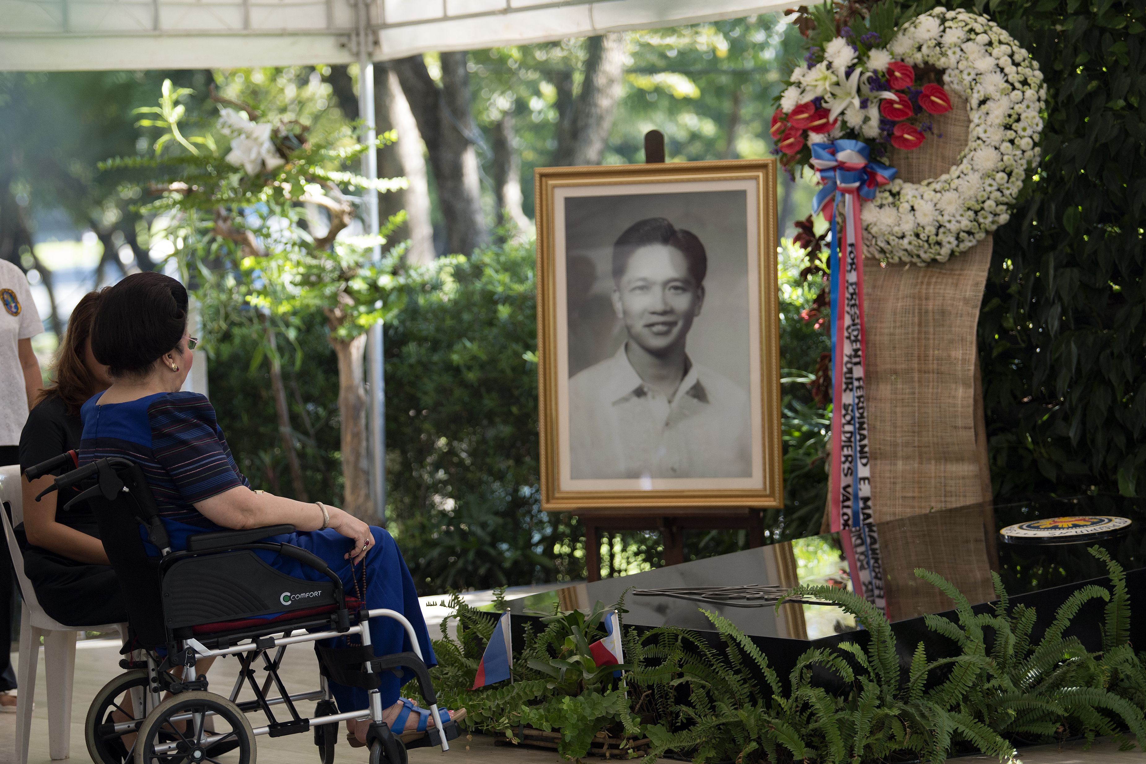 سيدة الفلبين الأولى السابقة تقف أمام صورة زوجها الراحل والرئيس السابق للبلاد