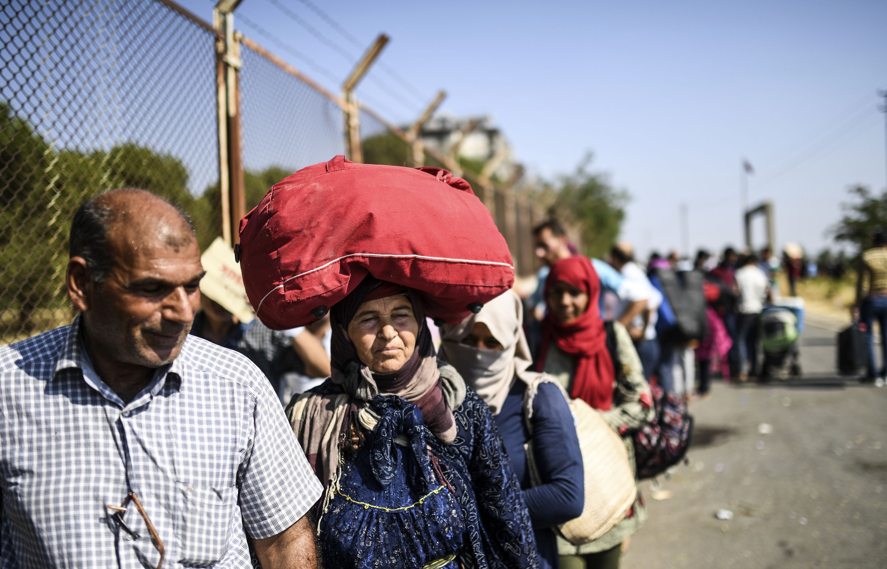 الأسر السورية تحمل امتعتها لعبور الحدود التركية إلى سوريا
