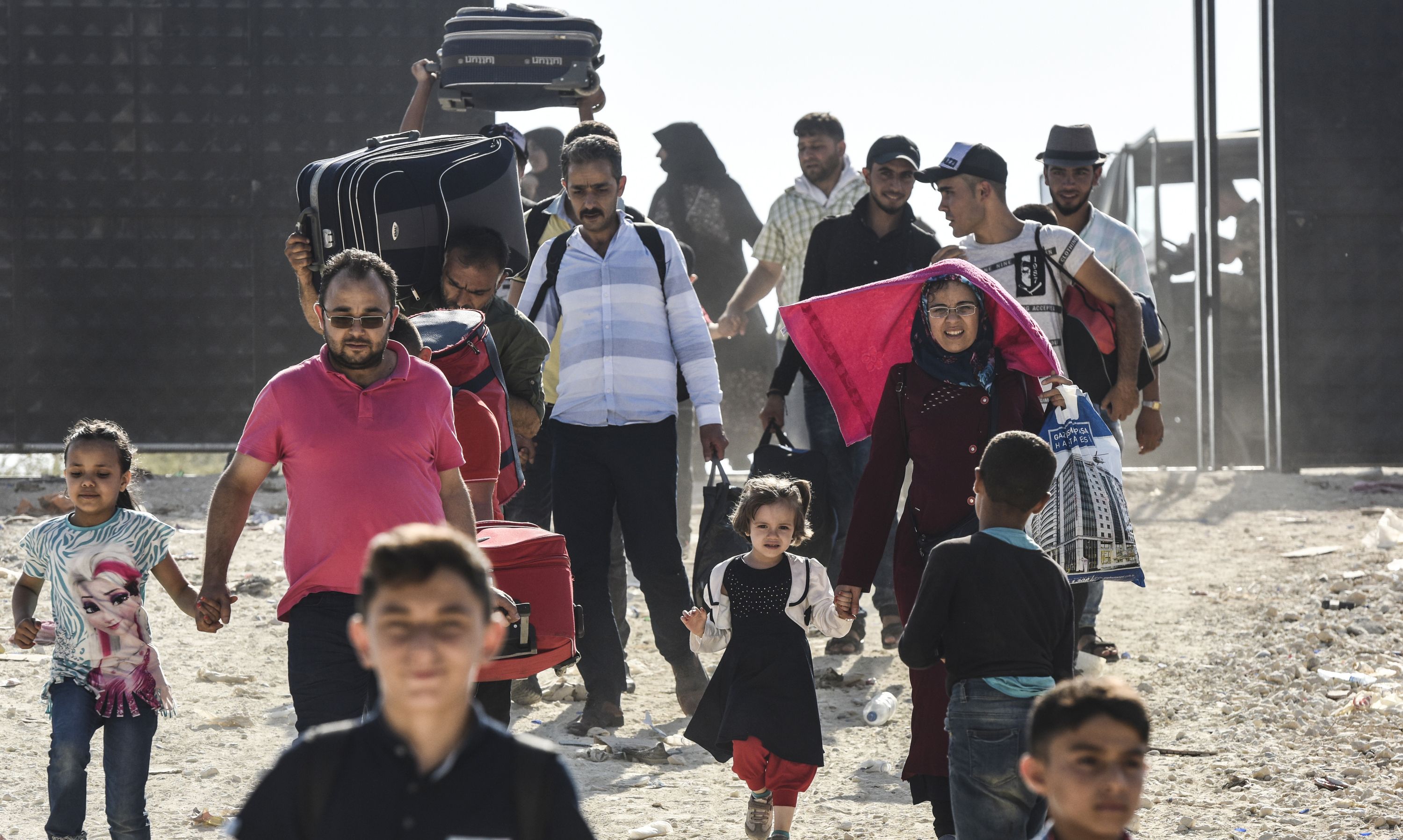 السيدات والأطفال يعبرون الحدود التركية لدخول سوريا