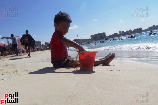 طفل يلعب بالرمال على شاطئ مطروح