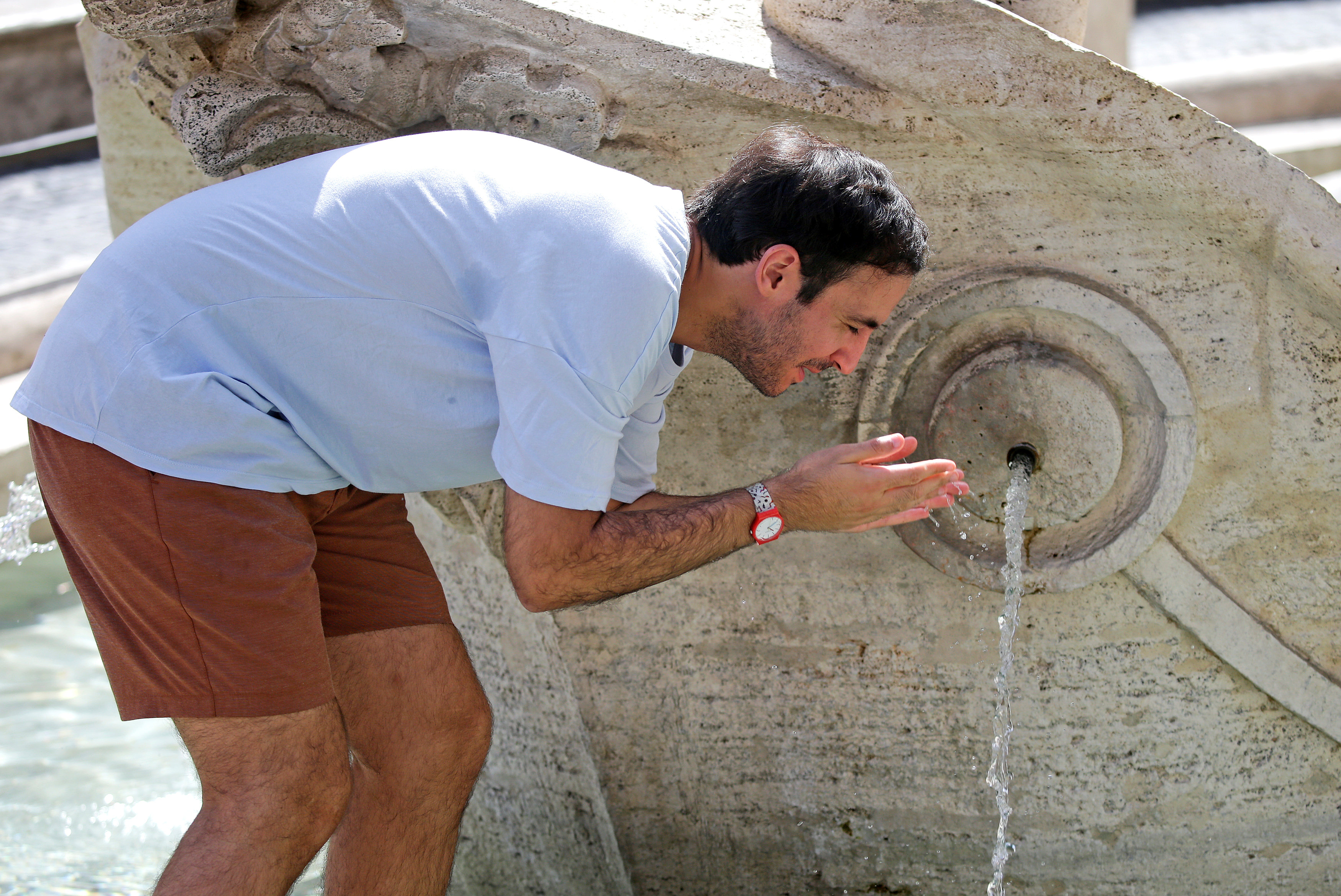 سائح يزور إيطاليا يستخدم المياه بسبب حرارة الجو