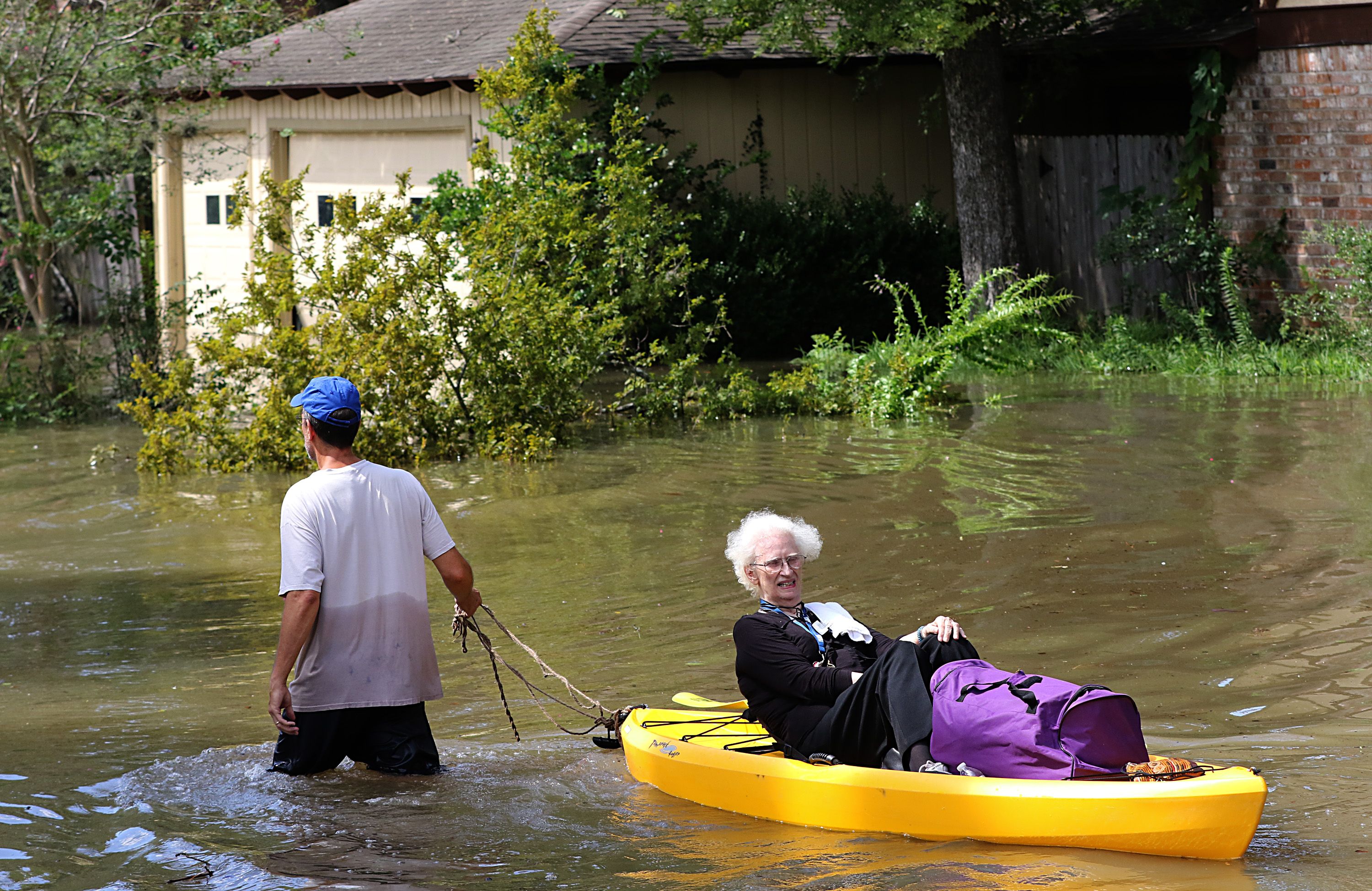 رحل يسحب سيدة عجوز على قارب صغير وسط مياه الاعصار