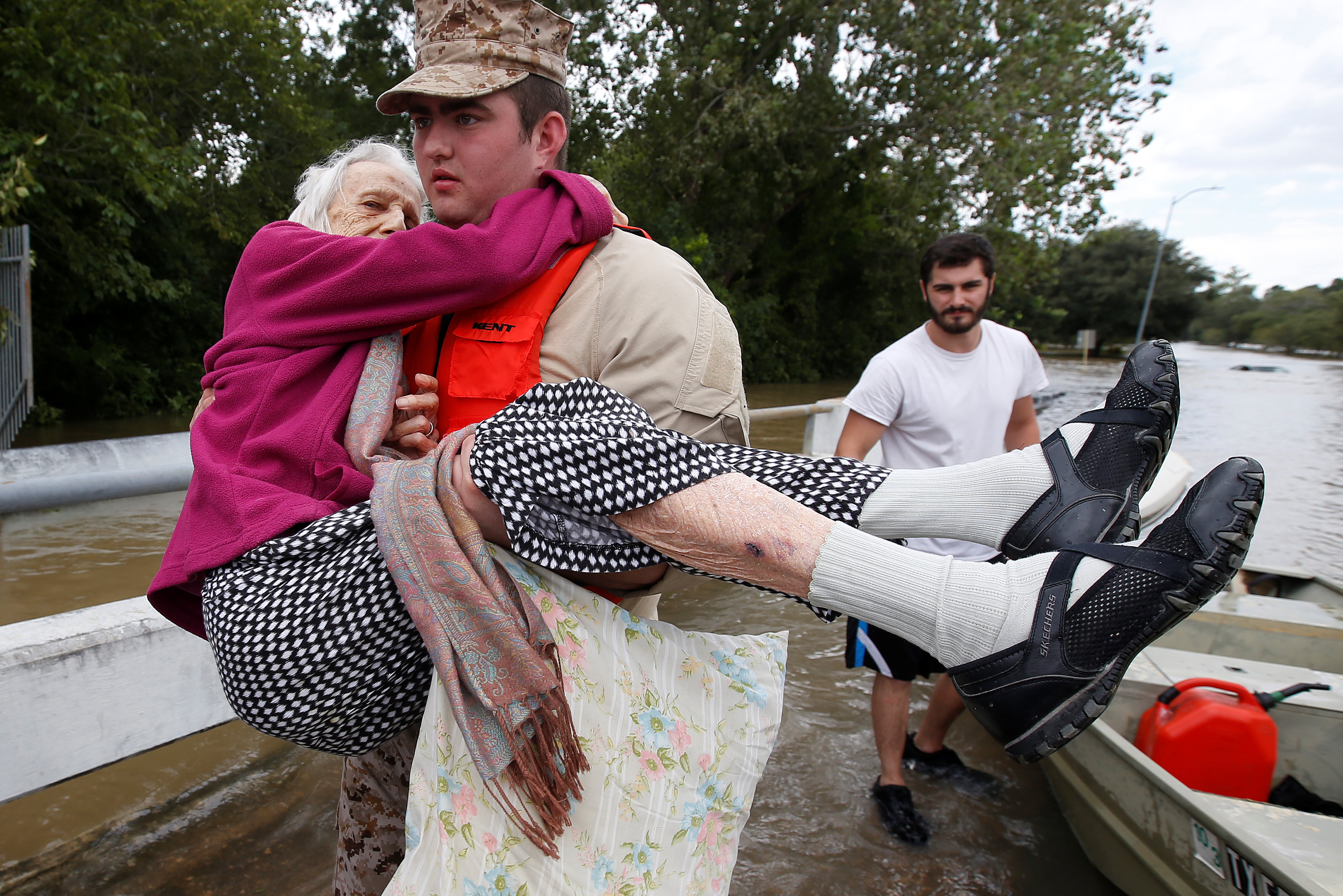 أحد عناصر الأمن الأمريكى يحمل مسنة أمريكية من مياه الإعصار