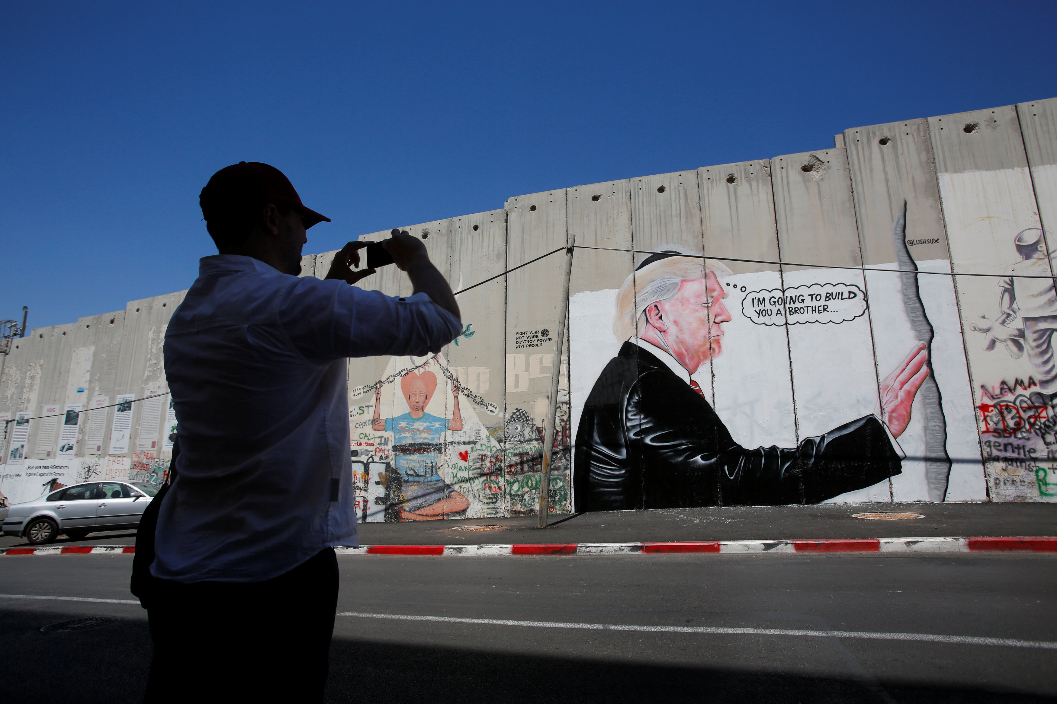 مواطن يلتقط صورة لجرافيتى ترامب